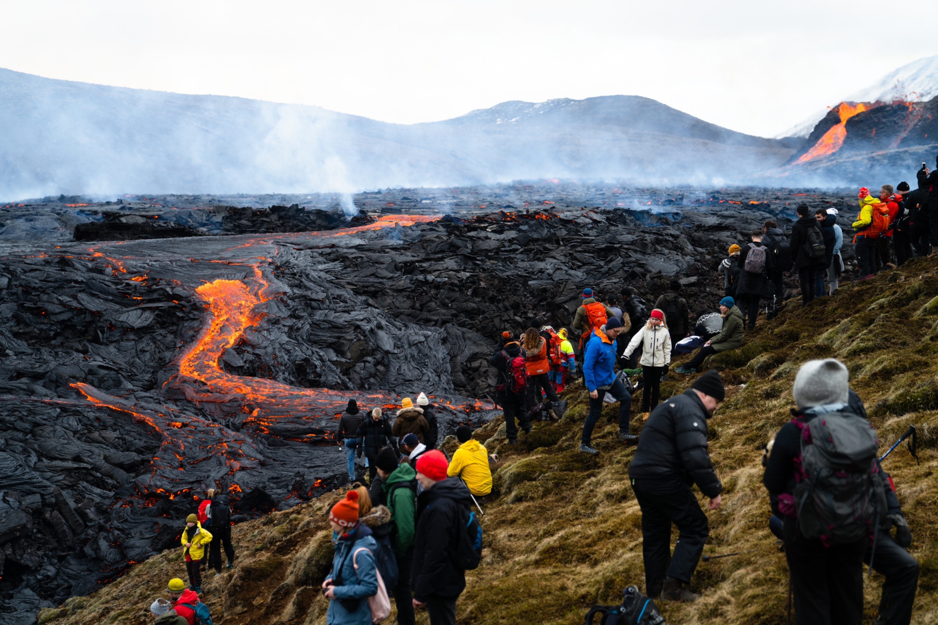 crowds of tourists walking around the flow of the erupted volcano