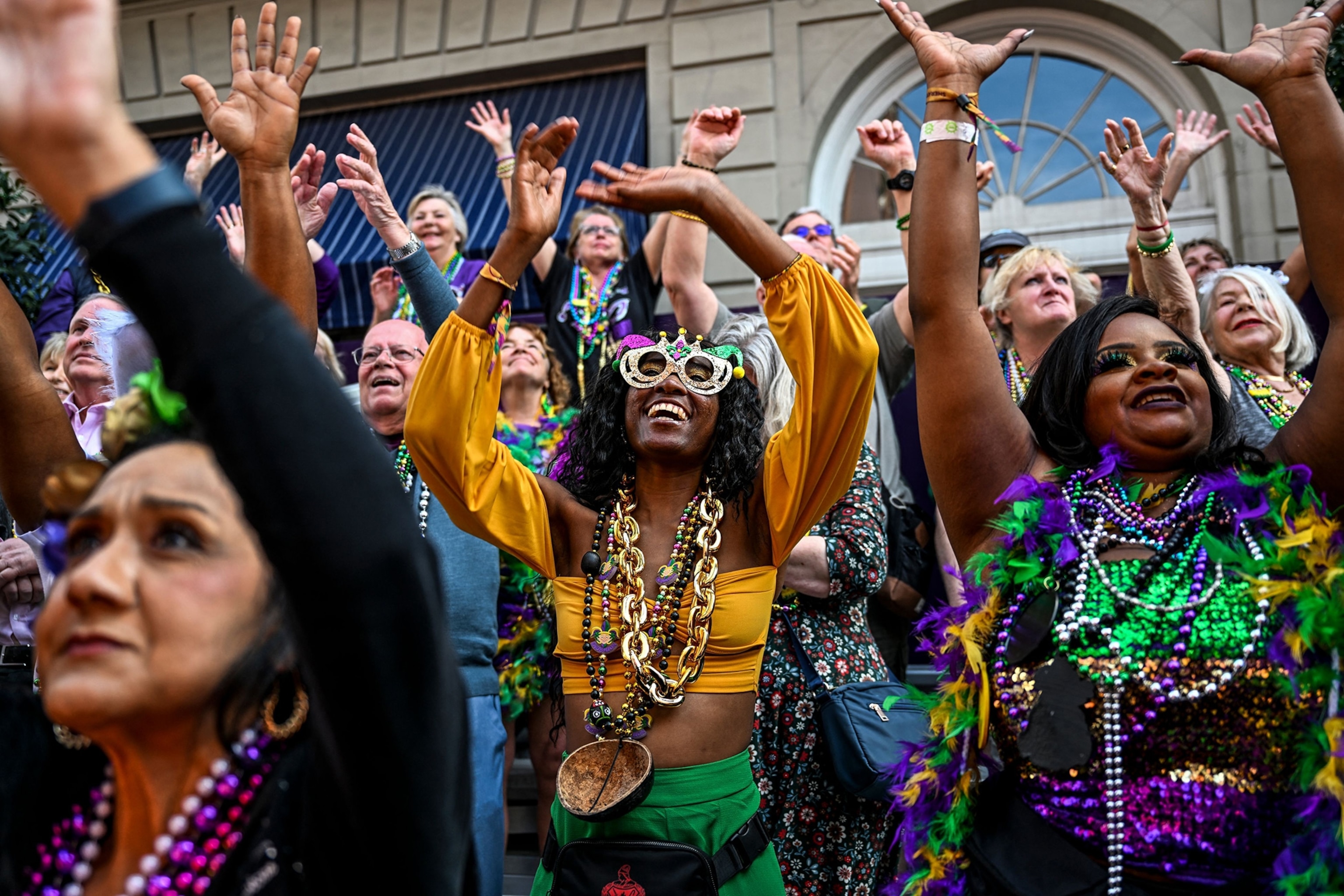 Revellers catch beads from a float in the 2023 Zulu Social Aid and Pleasure Club parade during a Mardi Gras celebration in New Orleans, Louisiana.