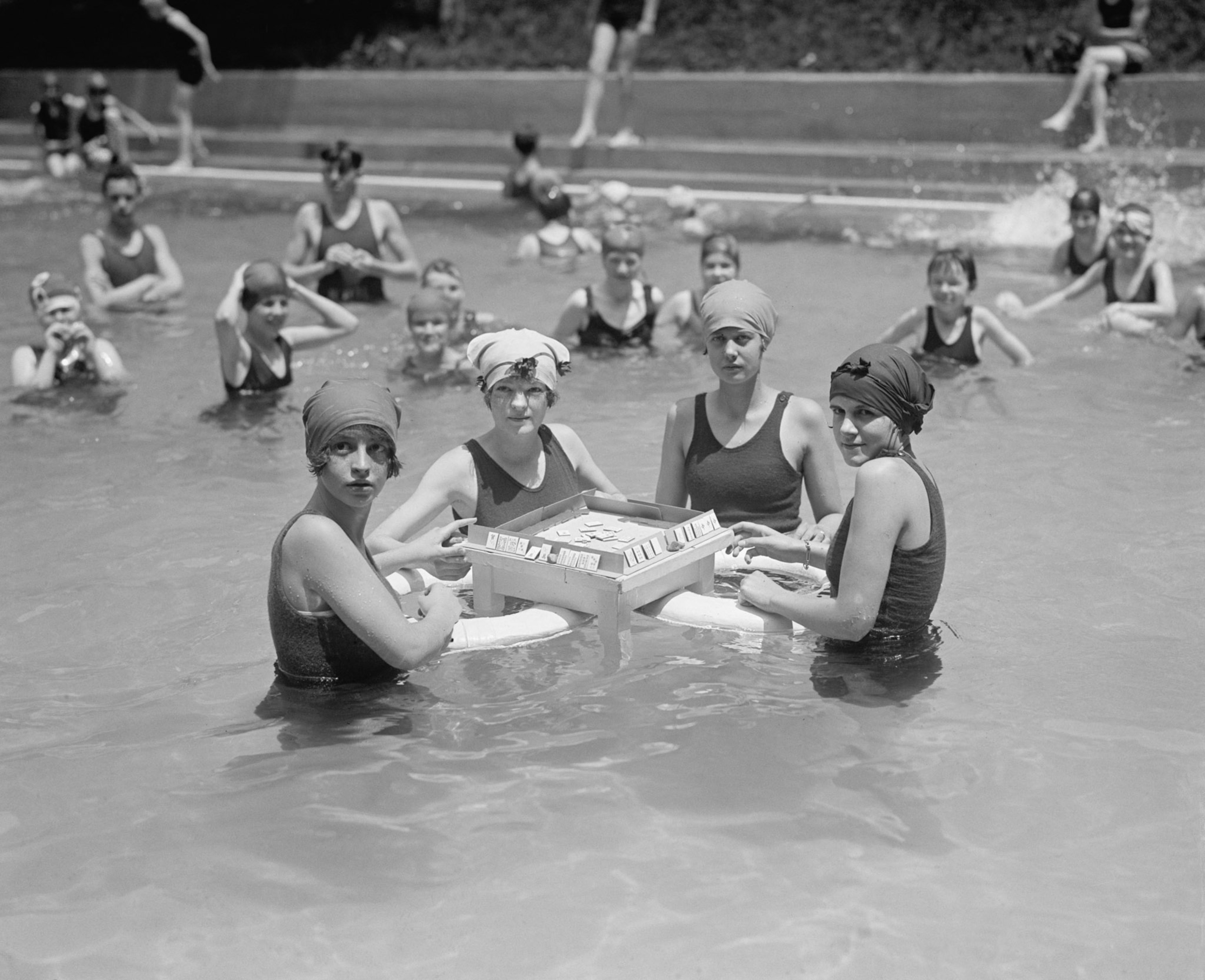 Women sitting in water playing Mahjong