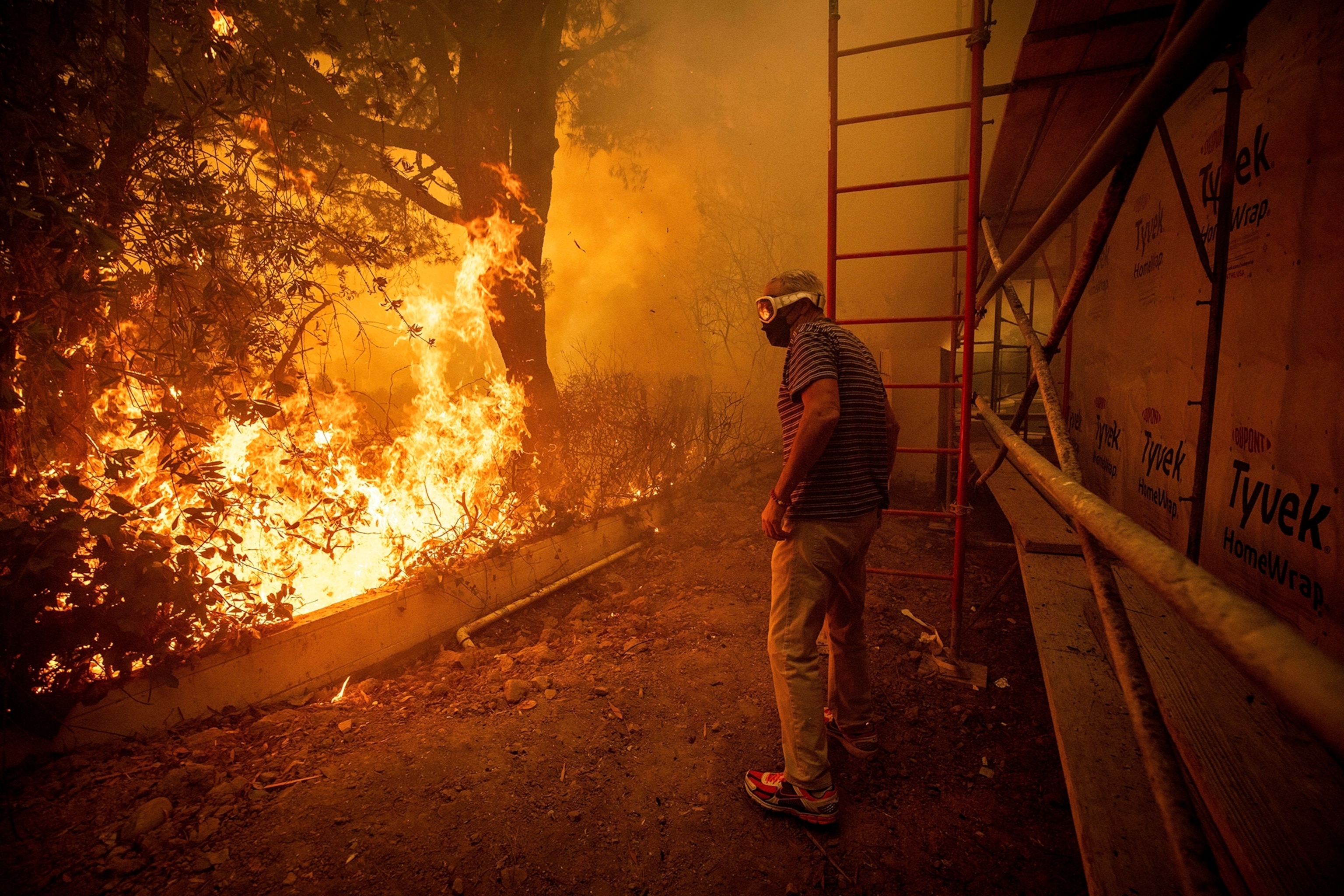 Will Adams watches as flames from the Palisades Fire close in on his property in the Pacific Palisades neighborhood of Los Angeles, Jan. 7, 2025.