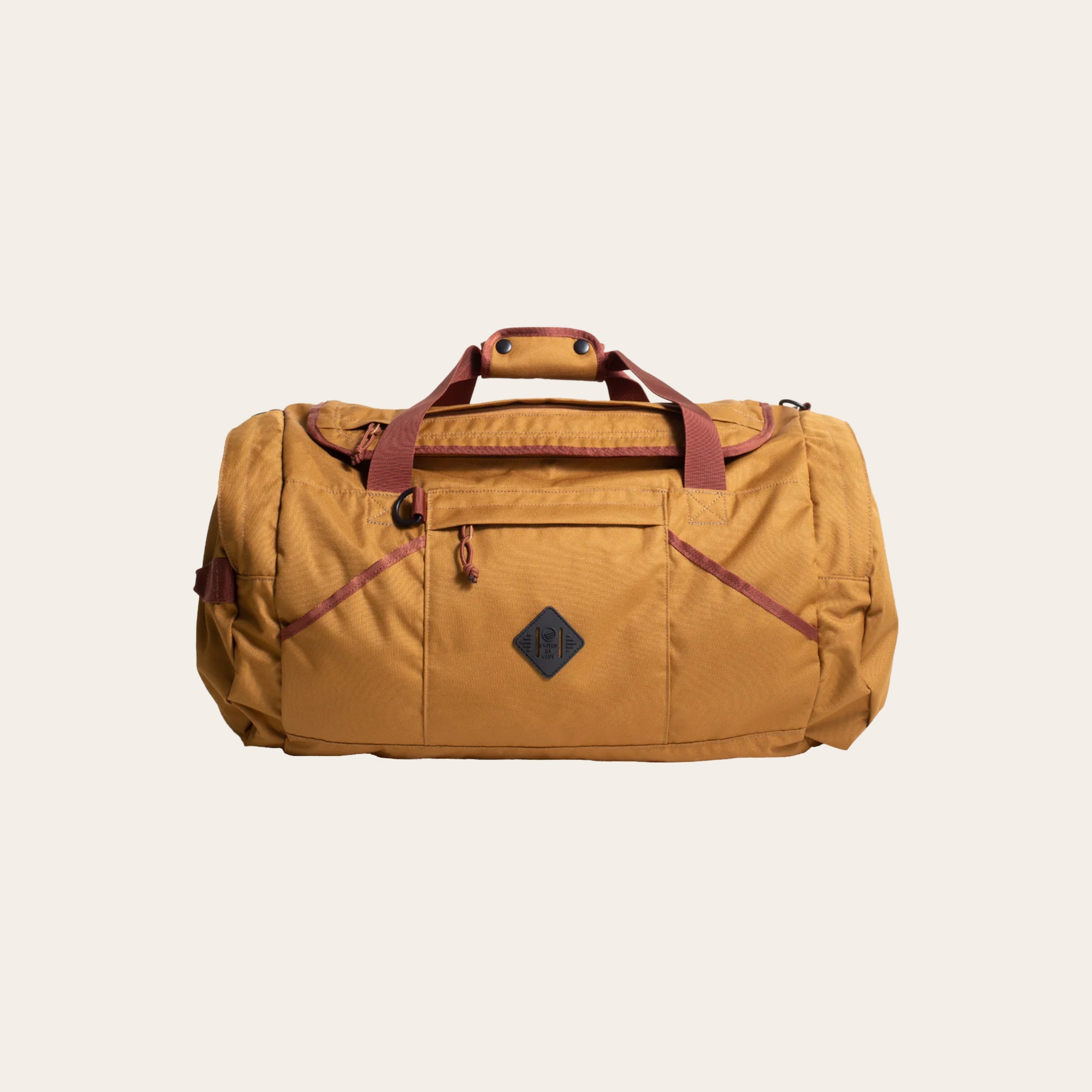 An orange-brown canvas duffel bag against a tan background.