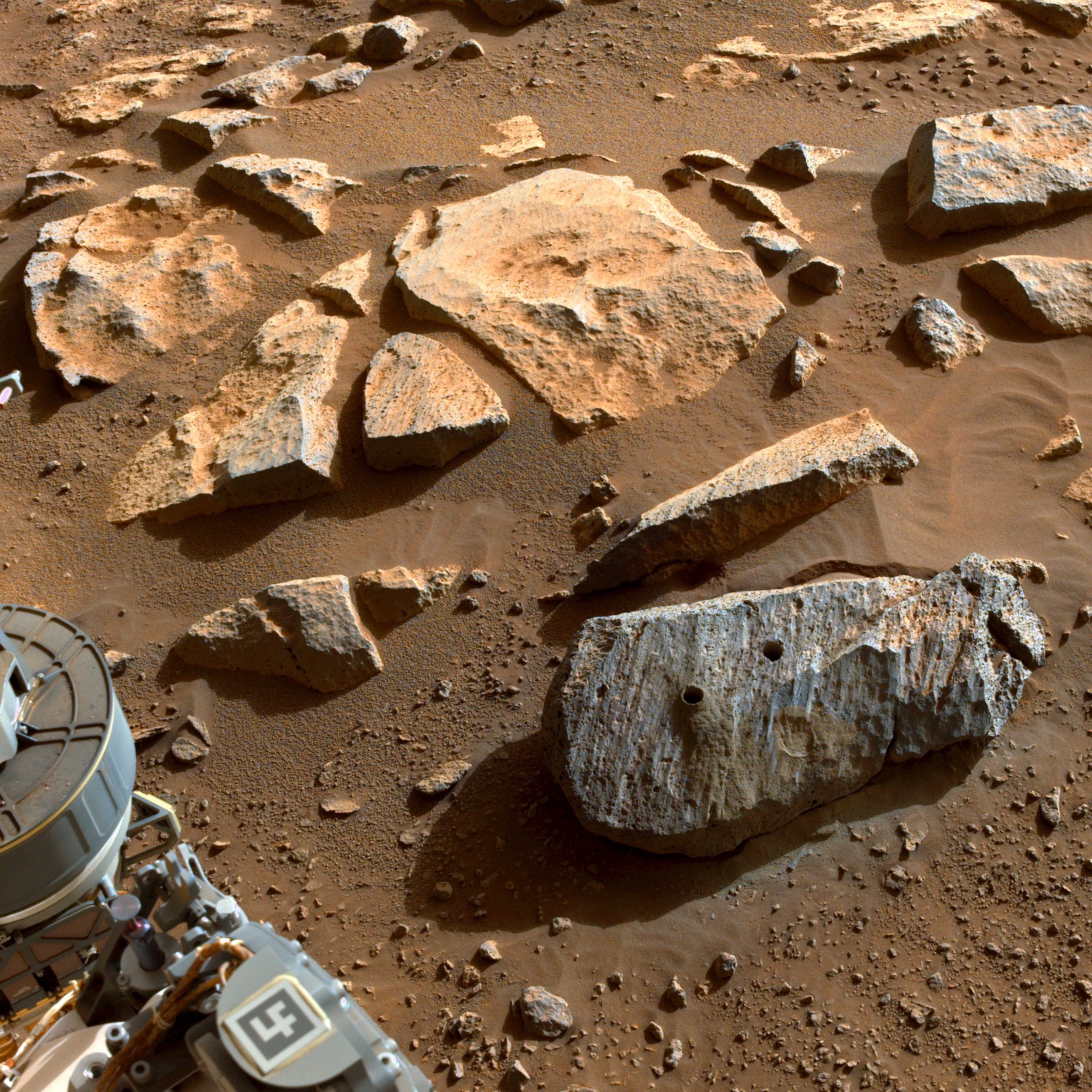 Picture of two holes can be seen where the rover used its robotic arm to drill rock core samples