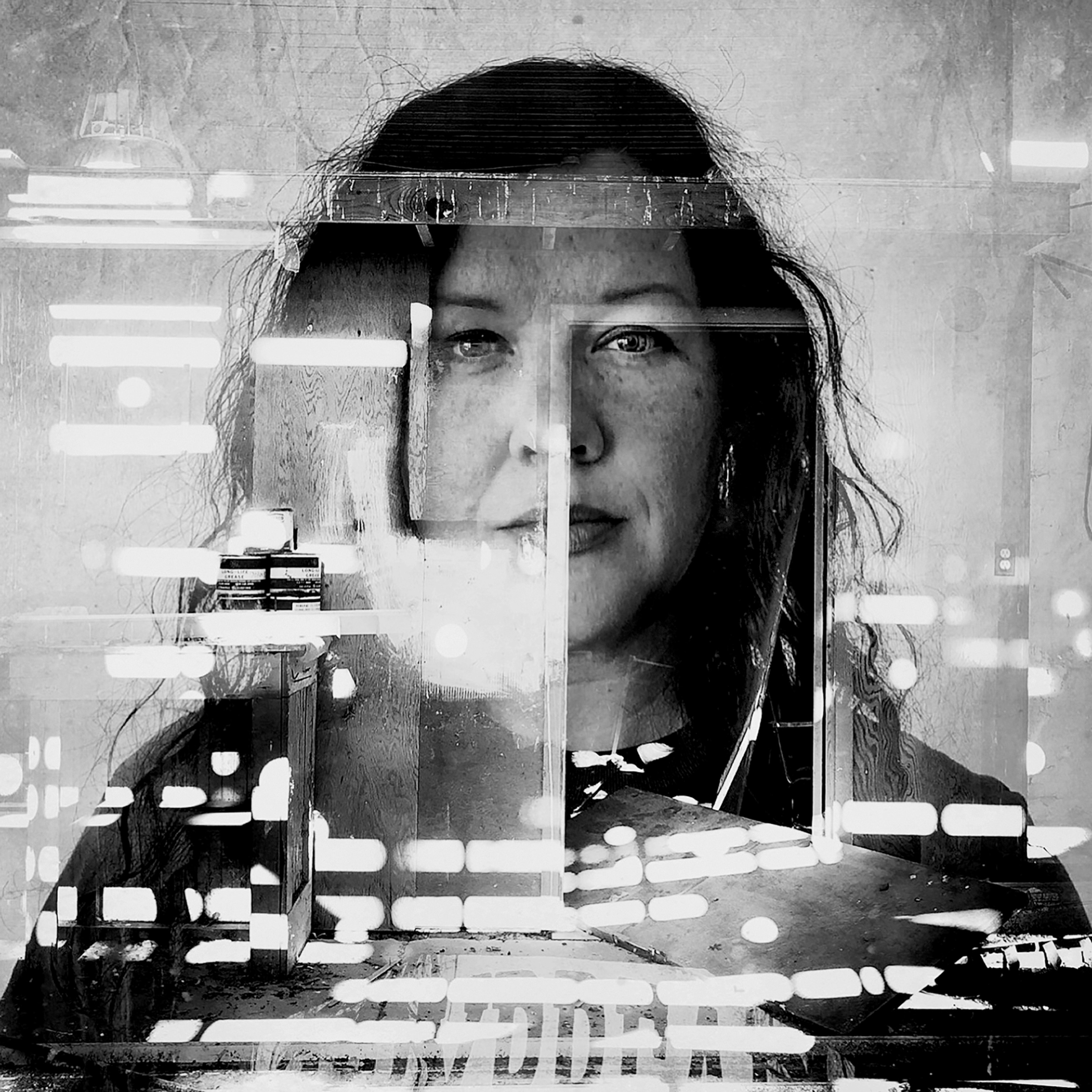 Picture of b&w portrait of woman seen through reflection on glass.