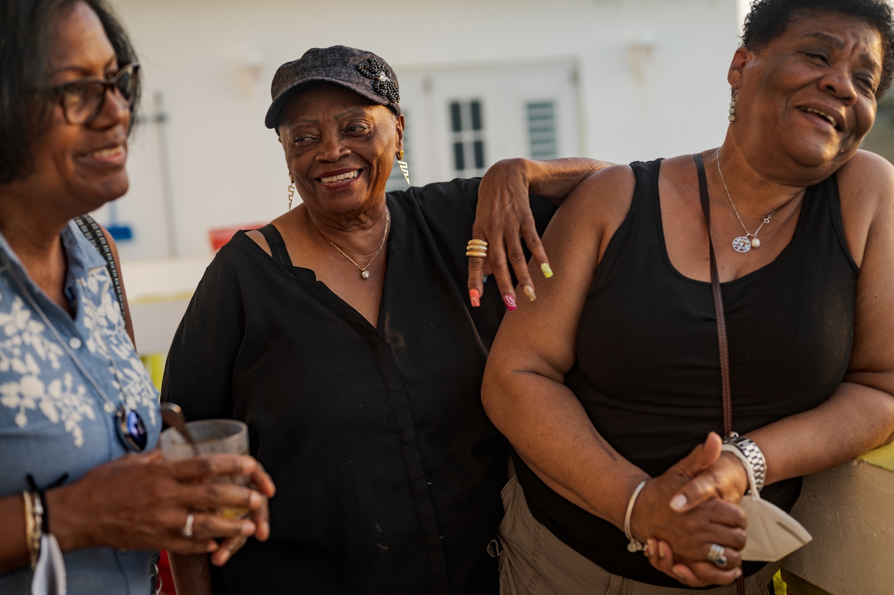 Three women smile and laugh together.