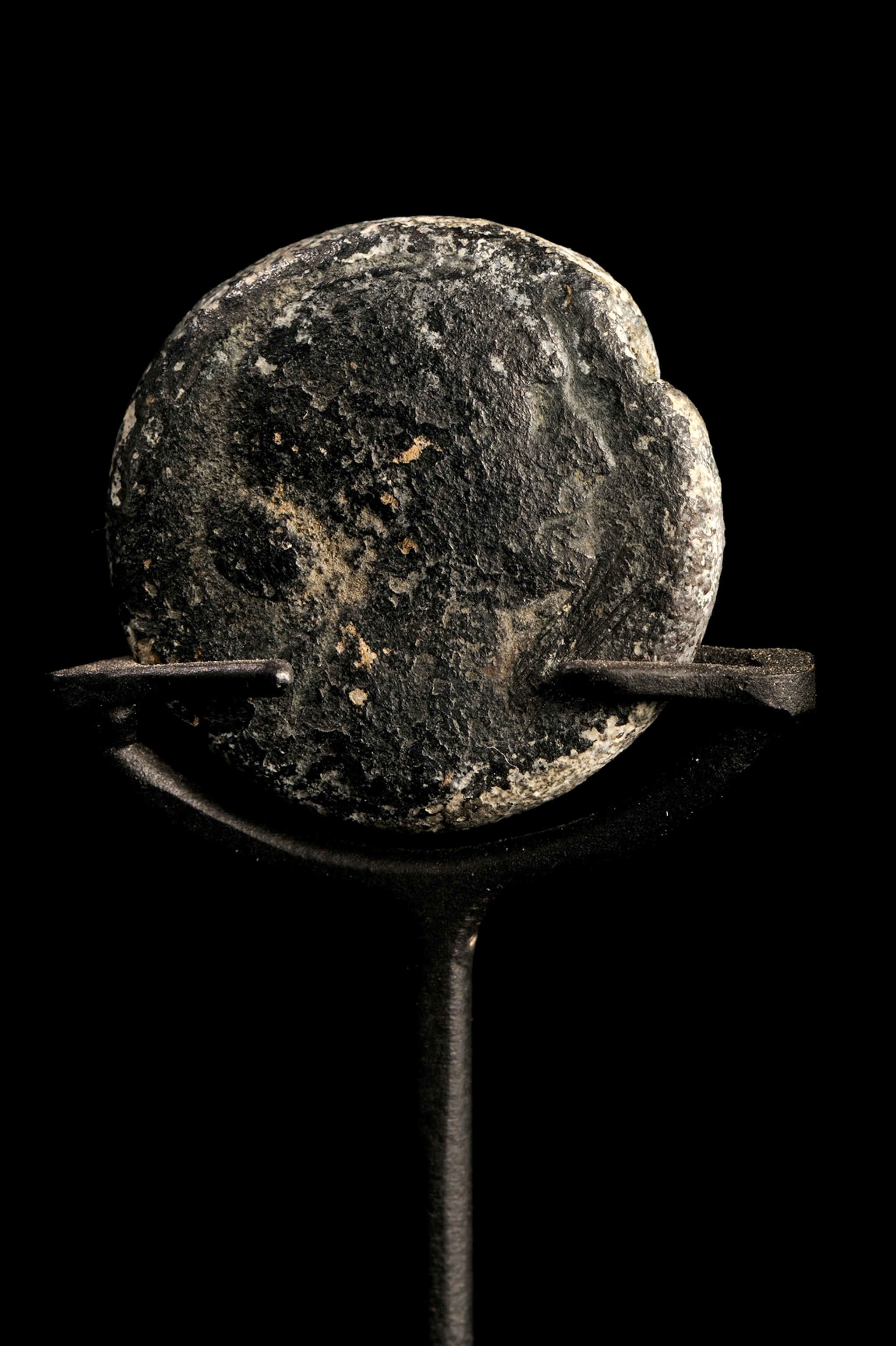A coin looks gray and deteriorating.