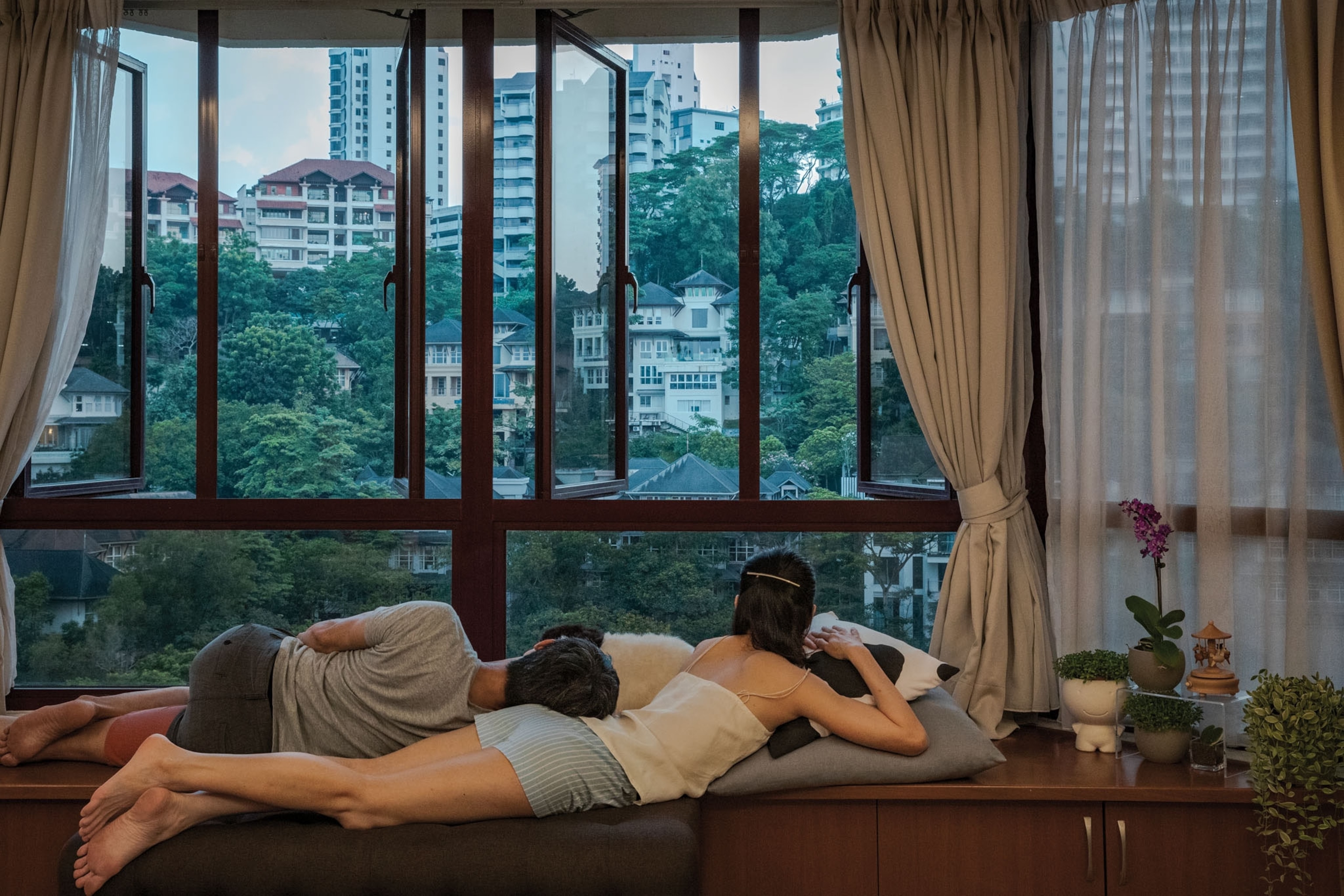 a couple looks outside their window during quarantine in Malaysia