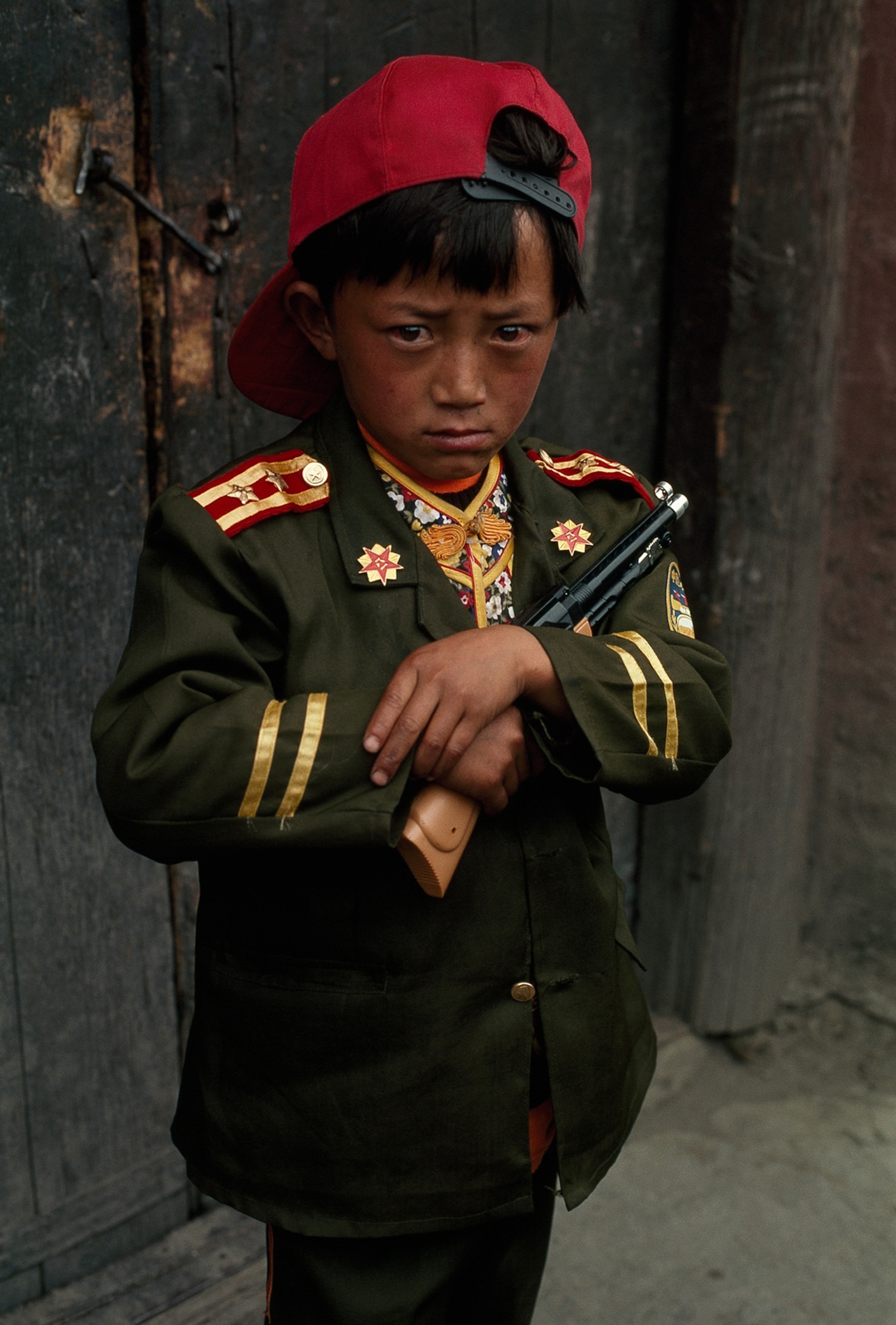 a Tibetan boy dressed as a Chinese policeman