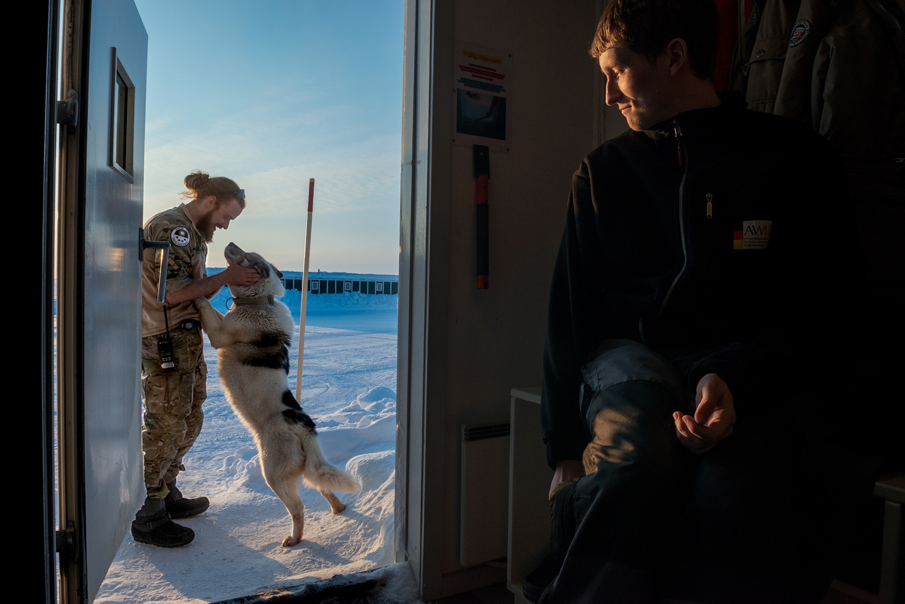 a soldier at the research station greeting a guard dog