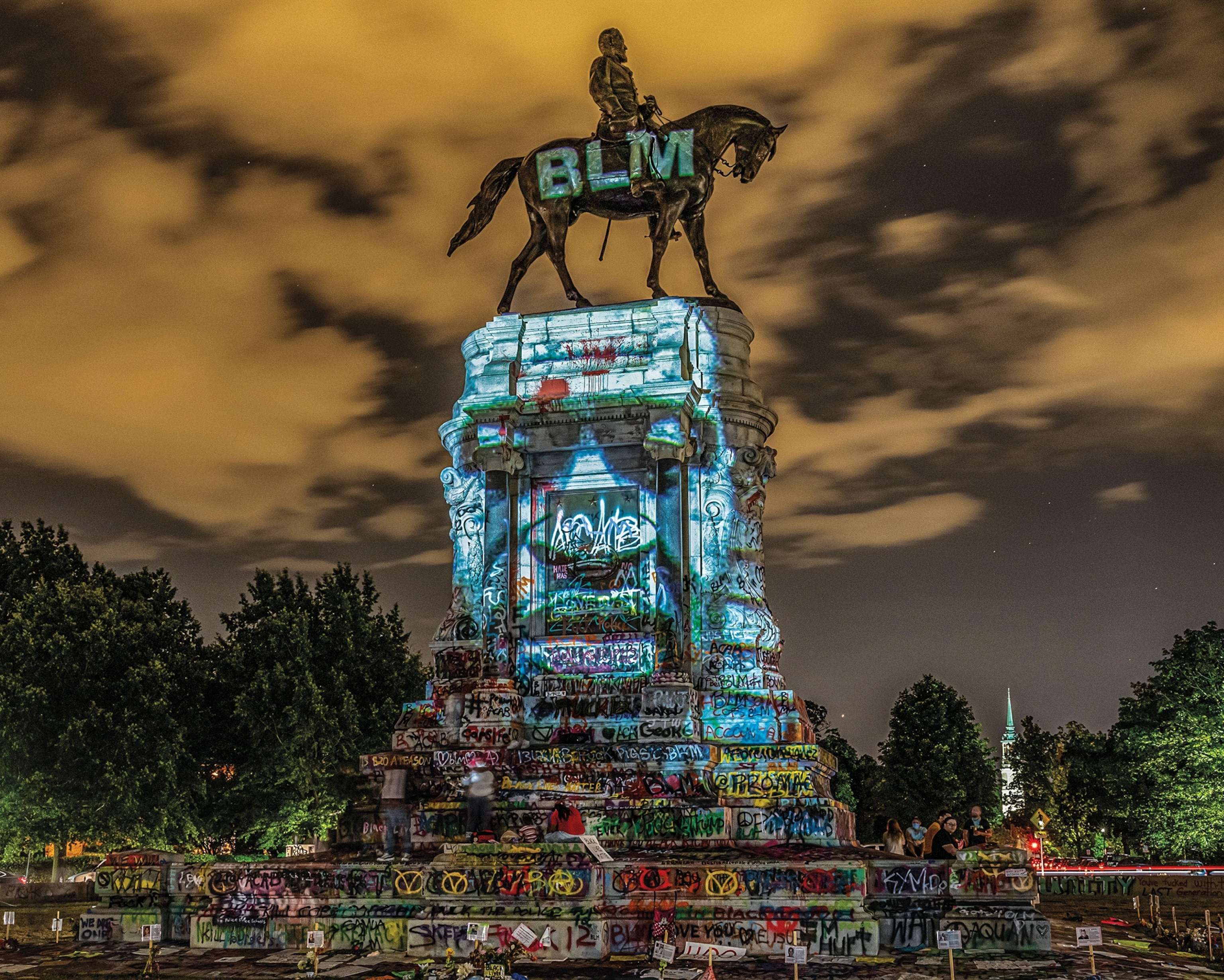 a statue of Robert E Lee with George Floyd's face projected onto the side