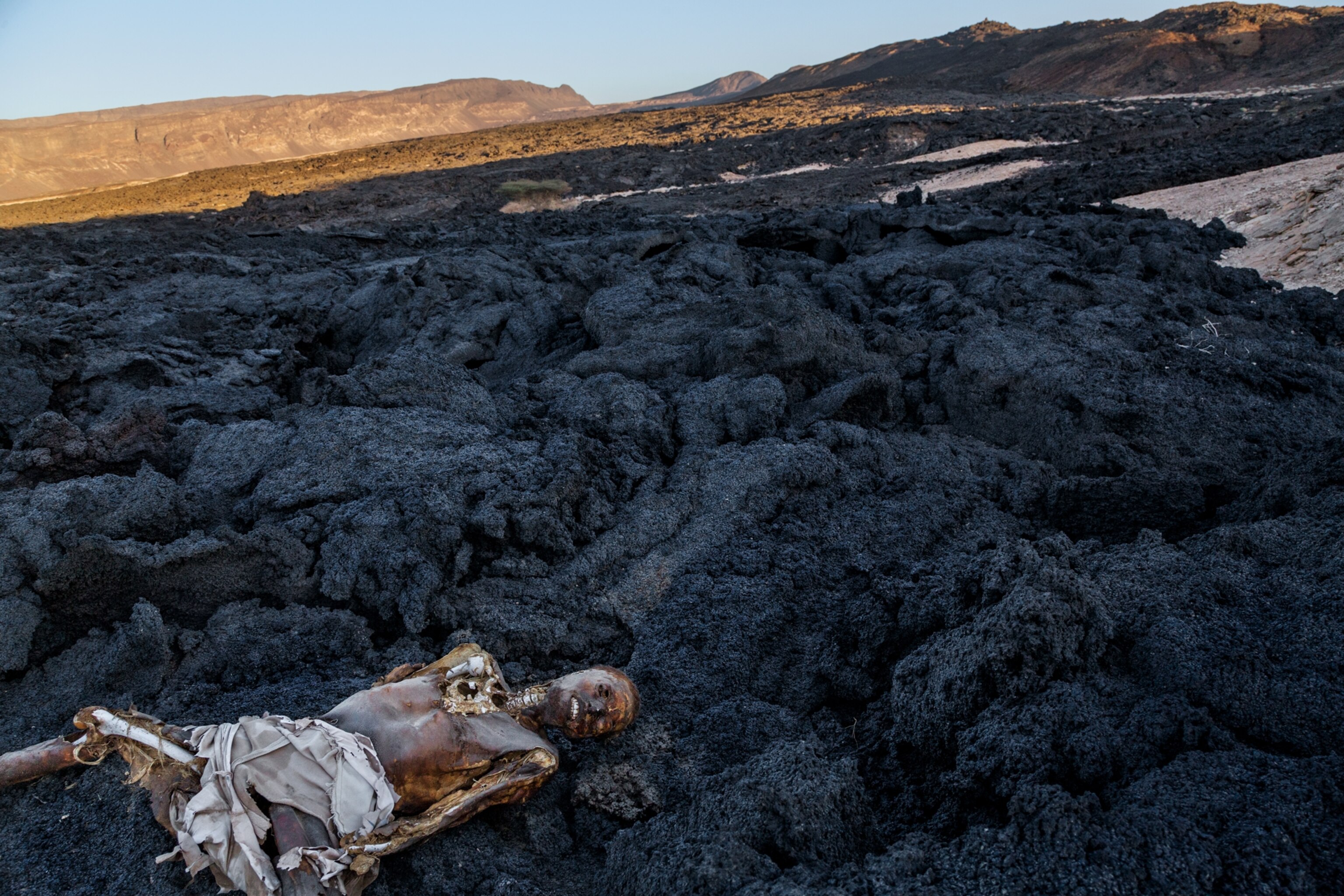 a corpse laying in a lava field