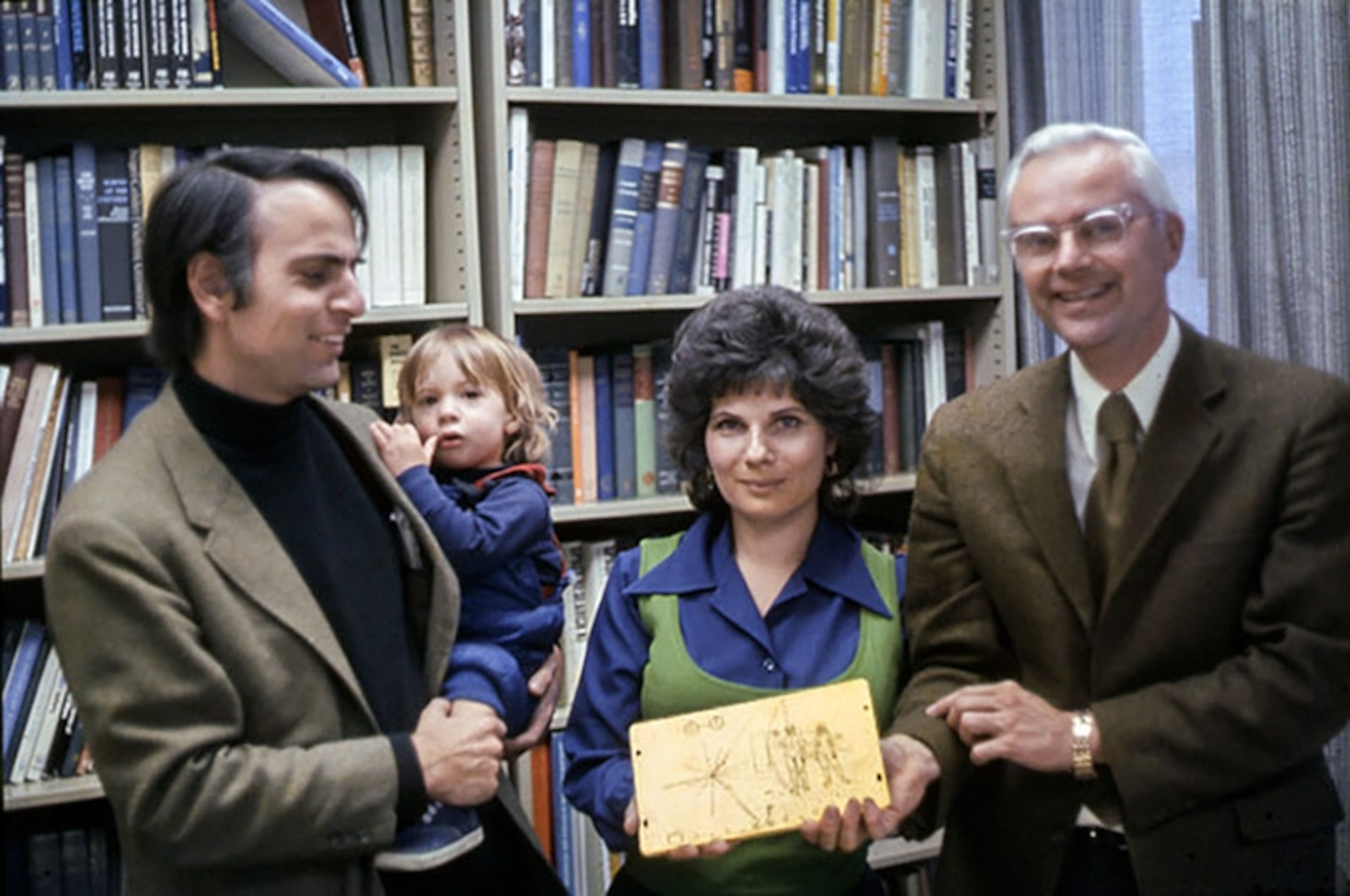 family photograph of two men, child and woman holding map.