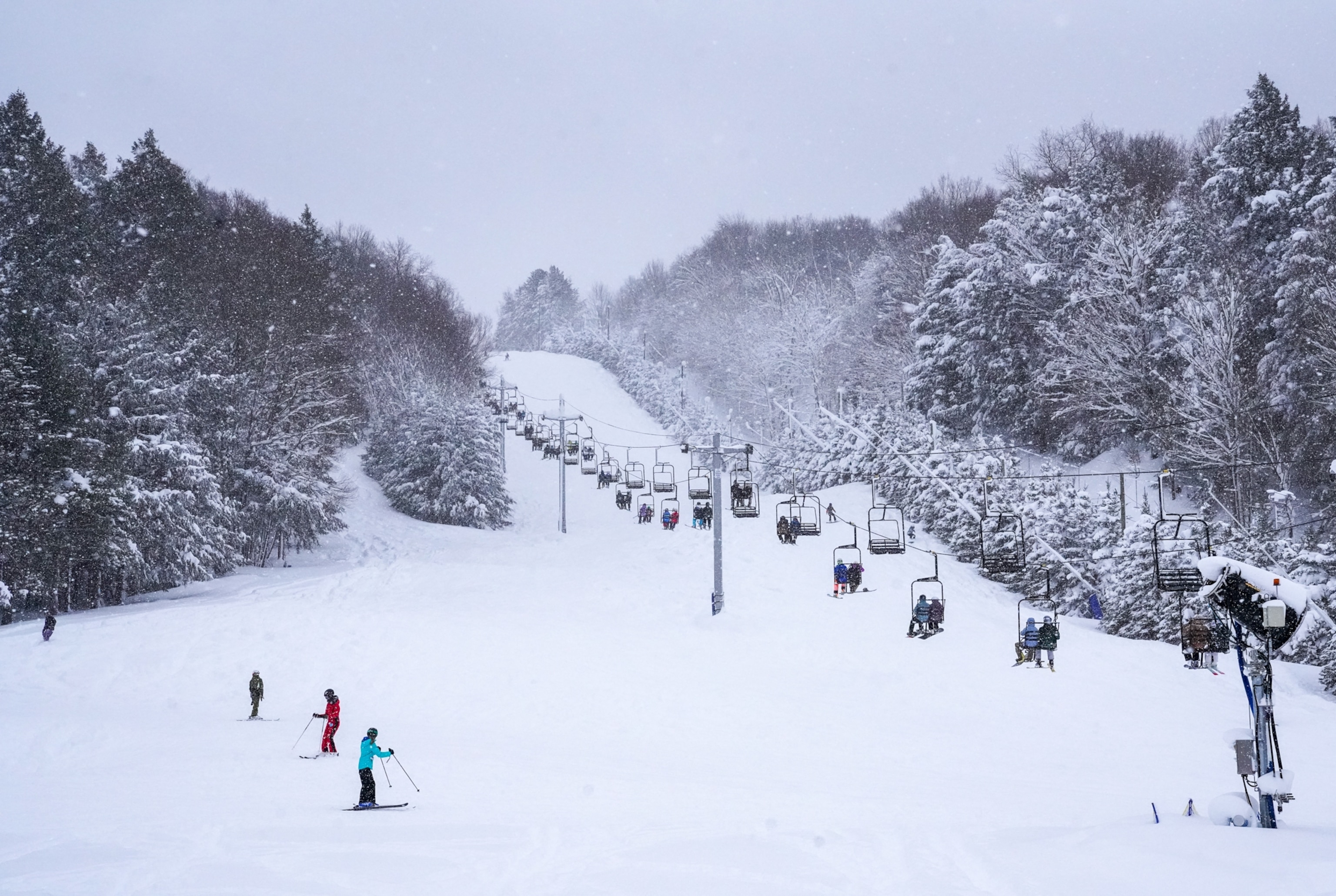 People around ski lifts on hills.