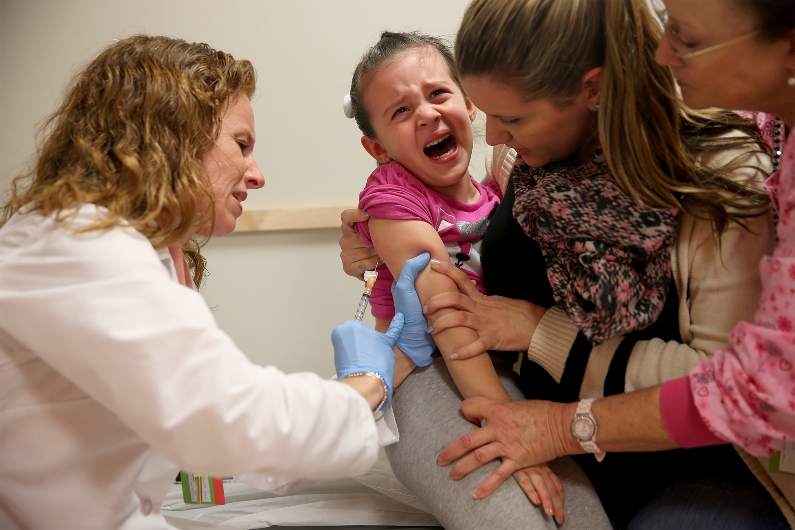 a doctor giving a measles vaccination to a child