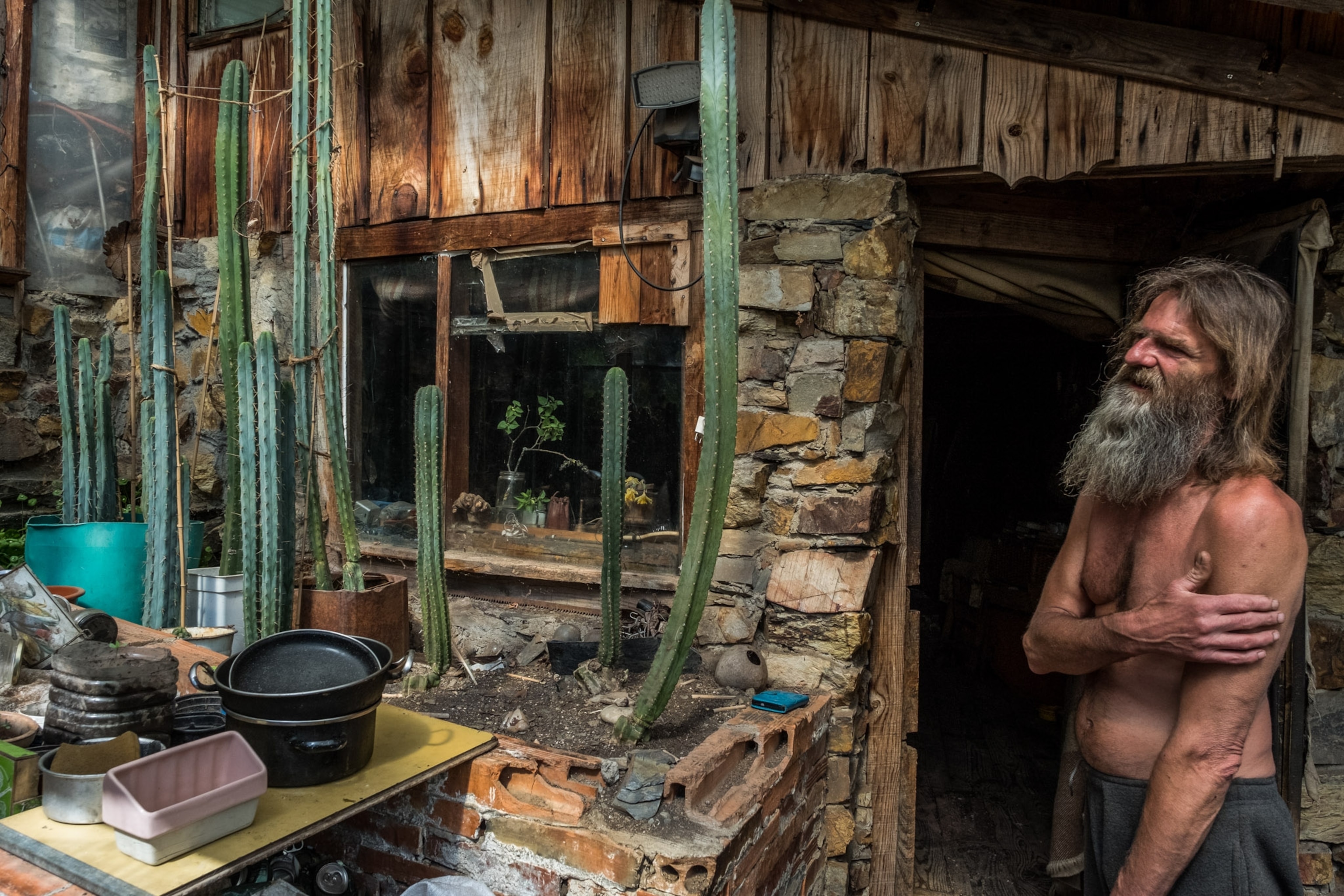 Photo of a man standing at the entrance of his house.