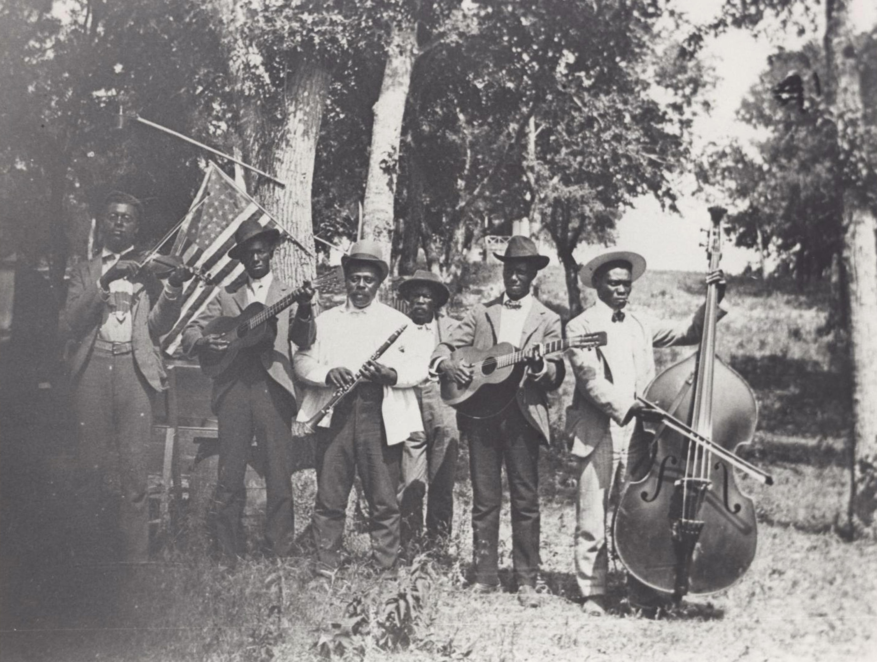 Musicians at 1900 Juneteenth celebration in Austin, Texas, pose before the U.S. flag.