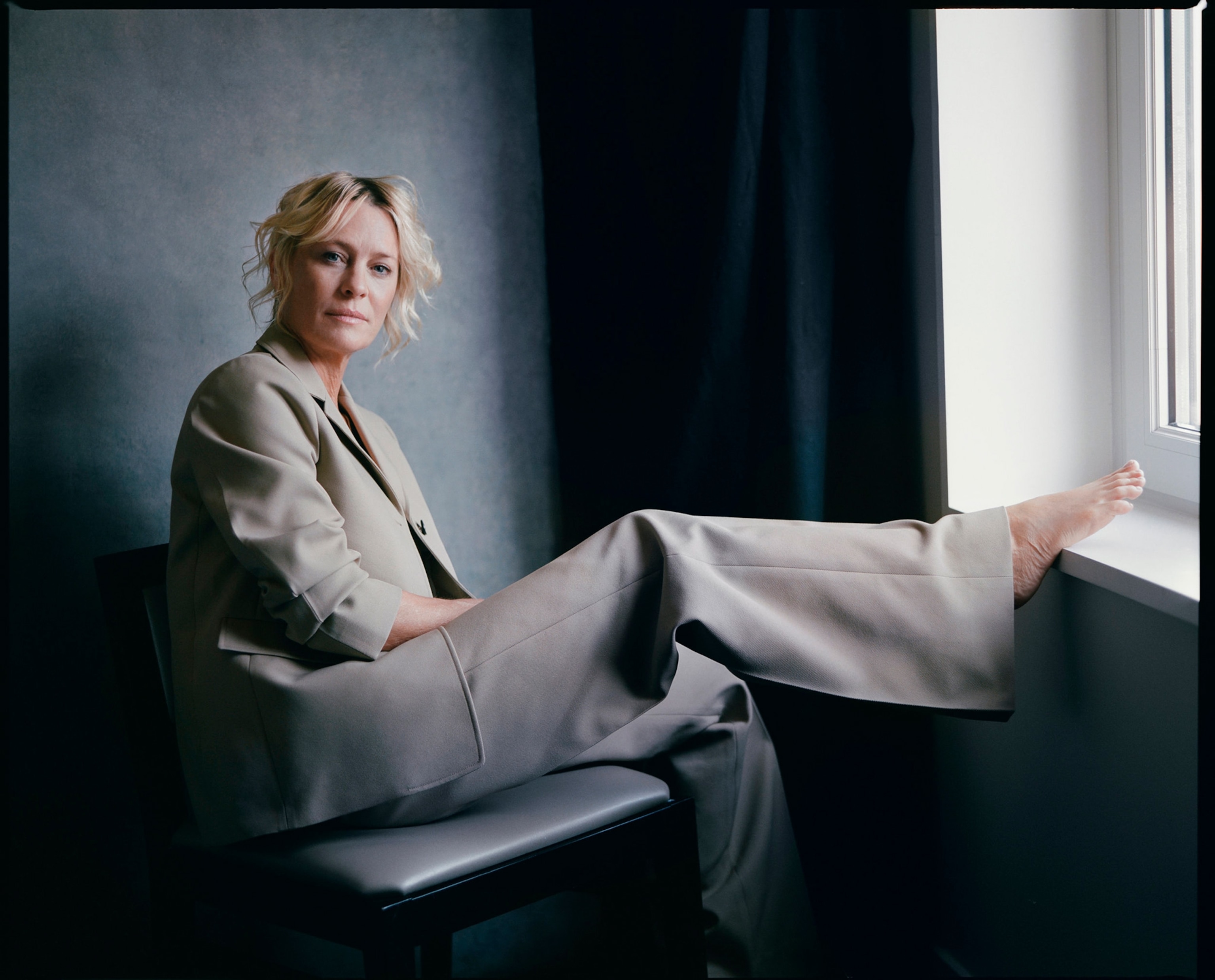 woman sitting on a chair with her legs up on the window sill