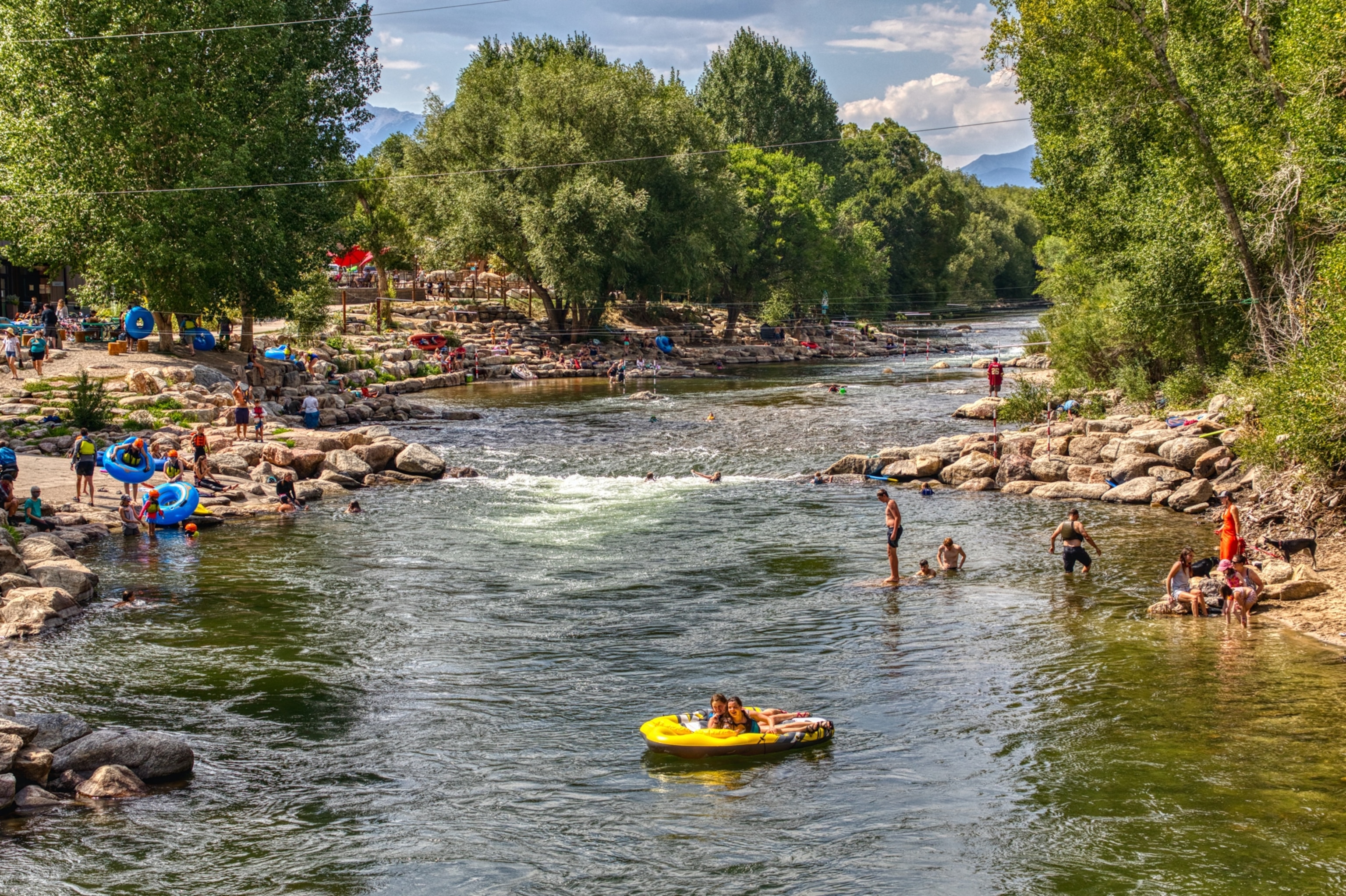 People playing in rafts on a river.