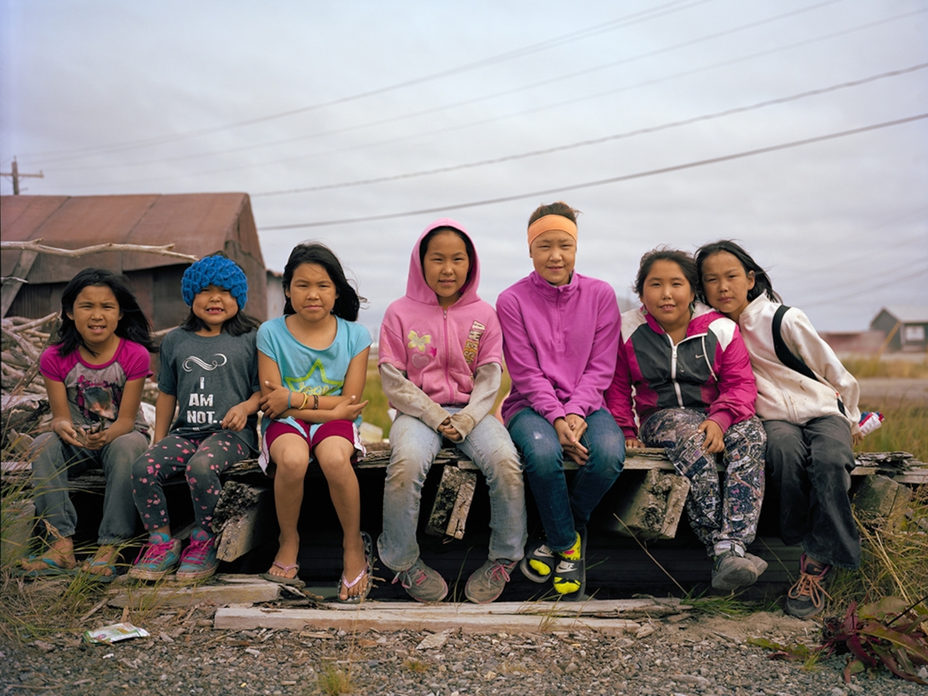 kids sitting next to each other on a bench