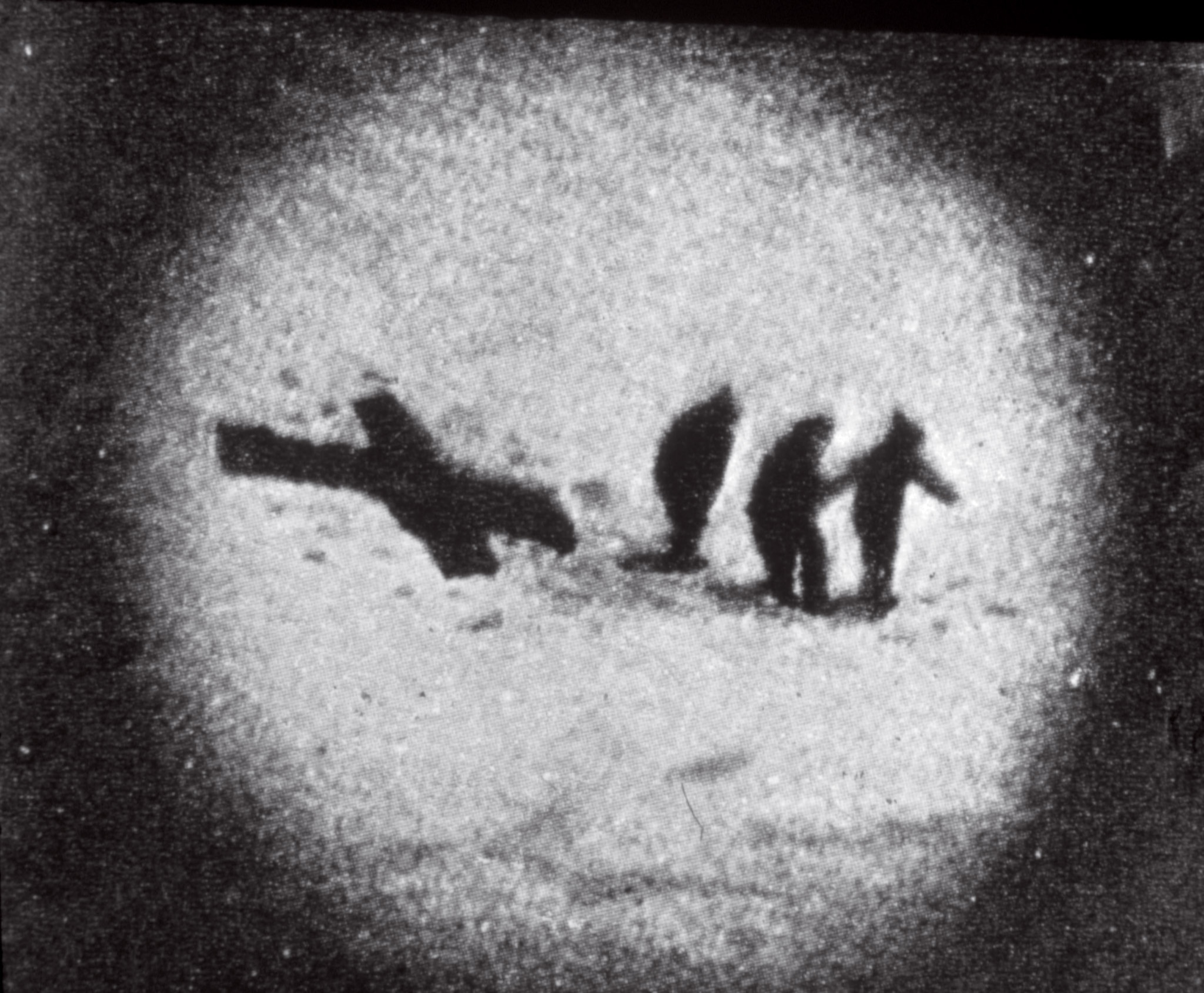 three silhouetted men next two two crossed sleeping bags