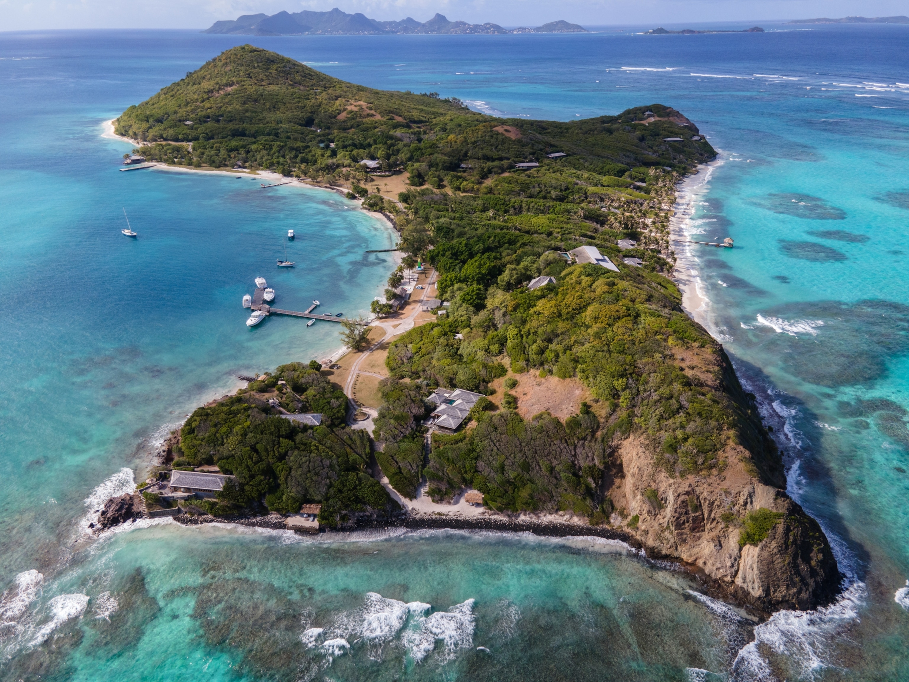 An aerial view of an island surrounded by bright a turquoise ocean.