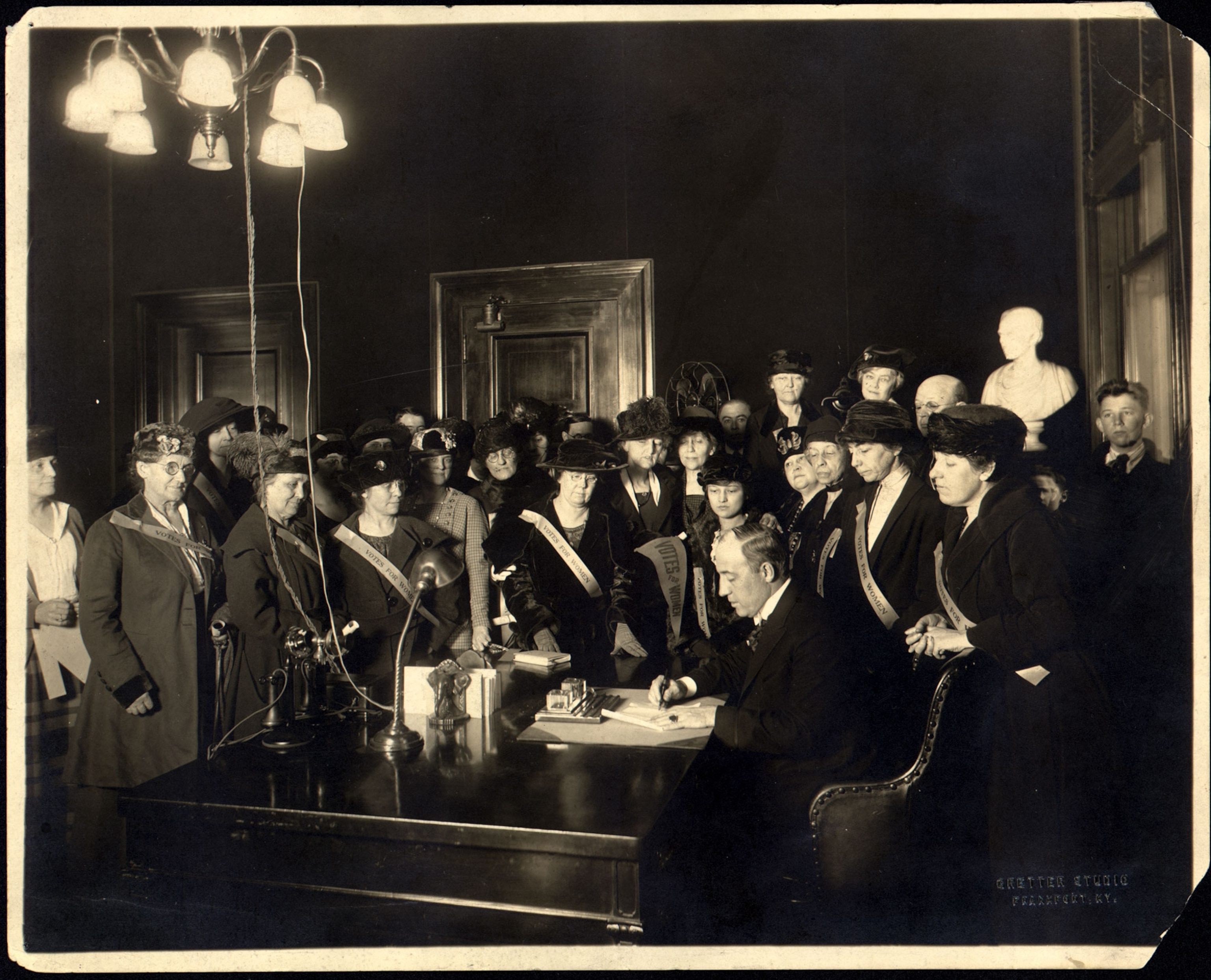 women watching an amendment being signed