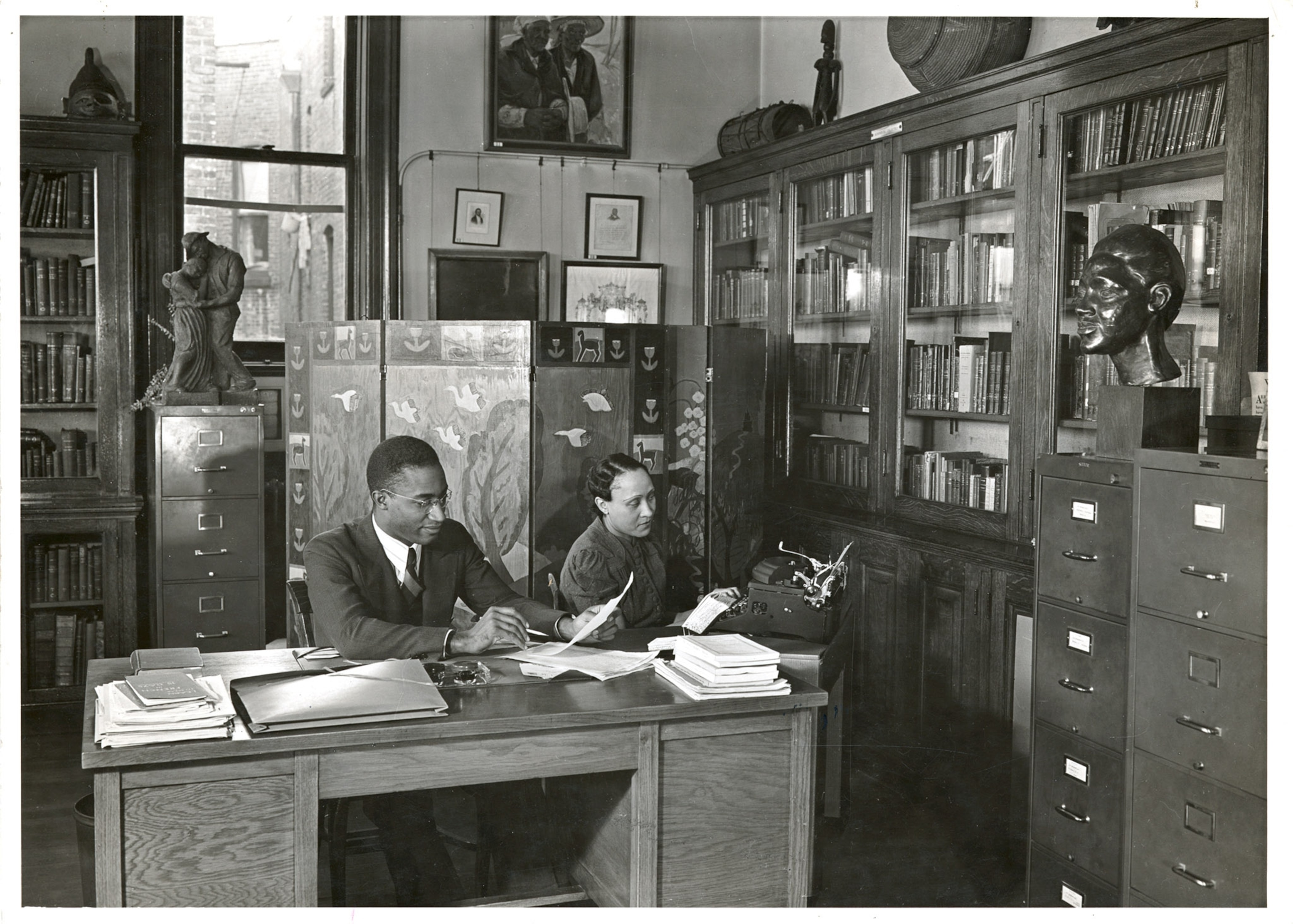 A man and woman are doing research at a table.