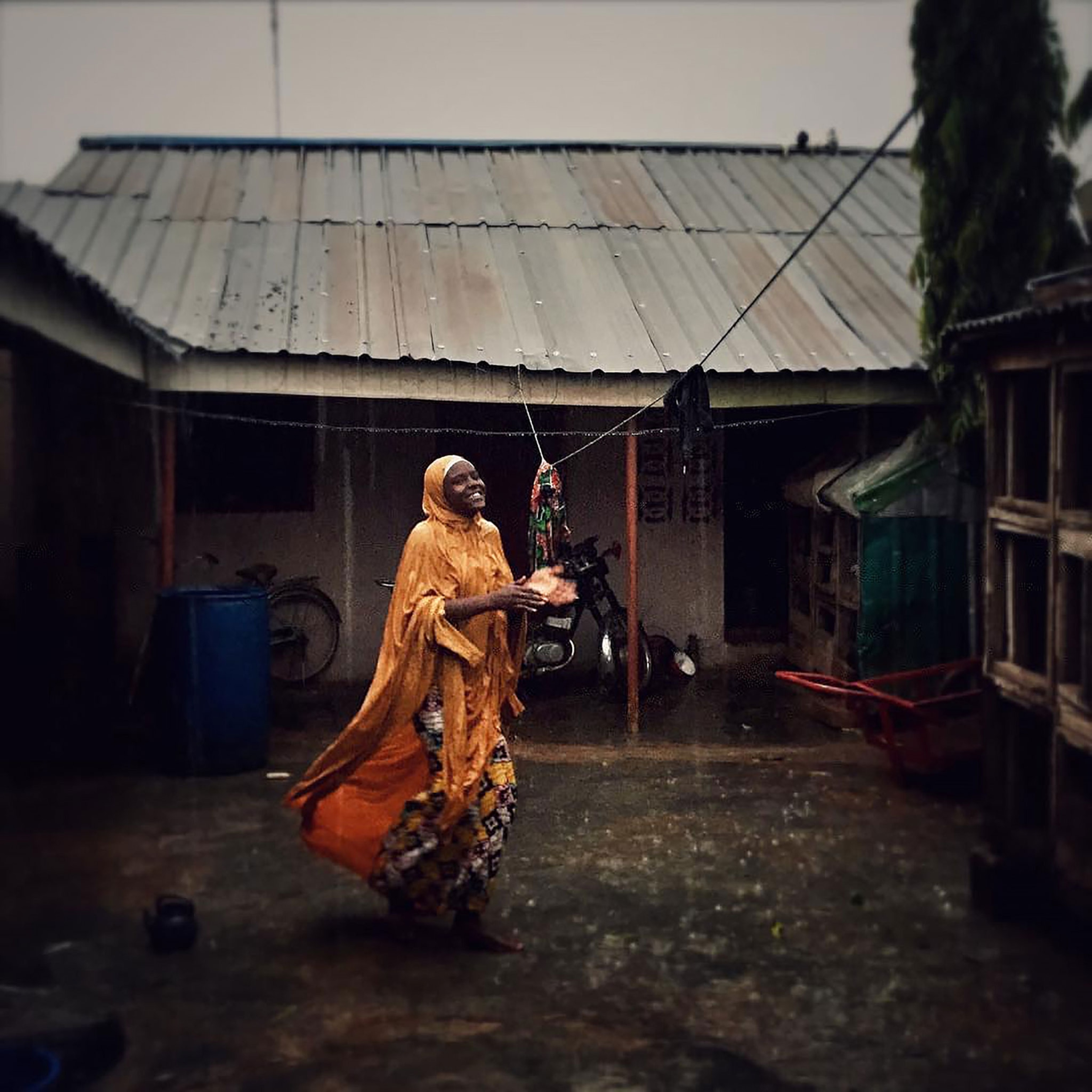 Amina plays in the rain in her village near Zaria, Nigeria