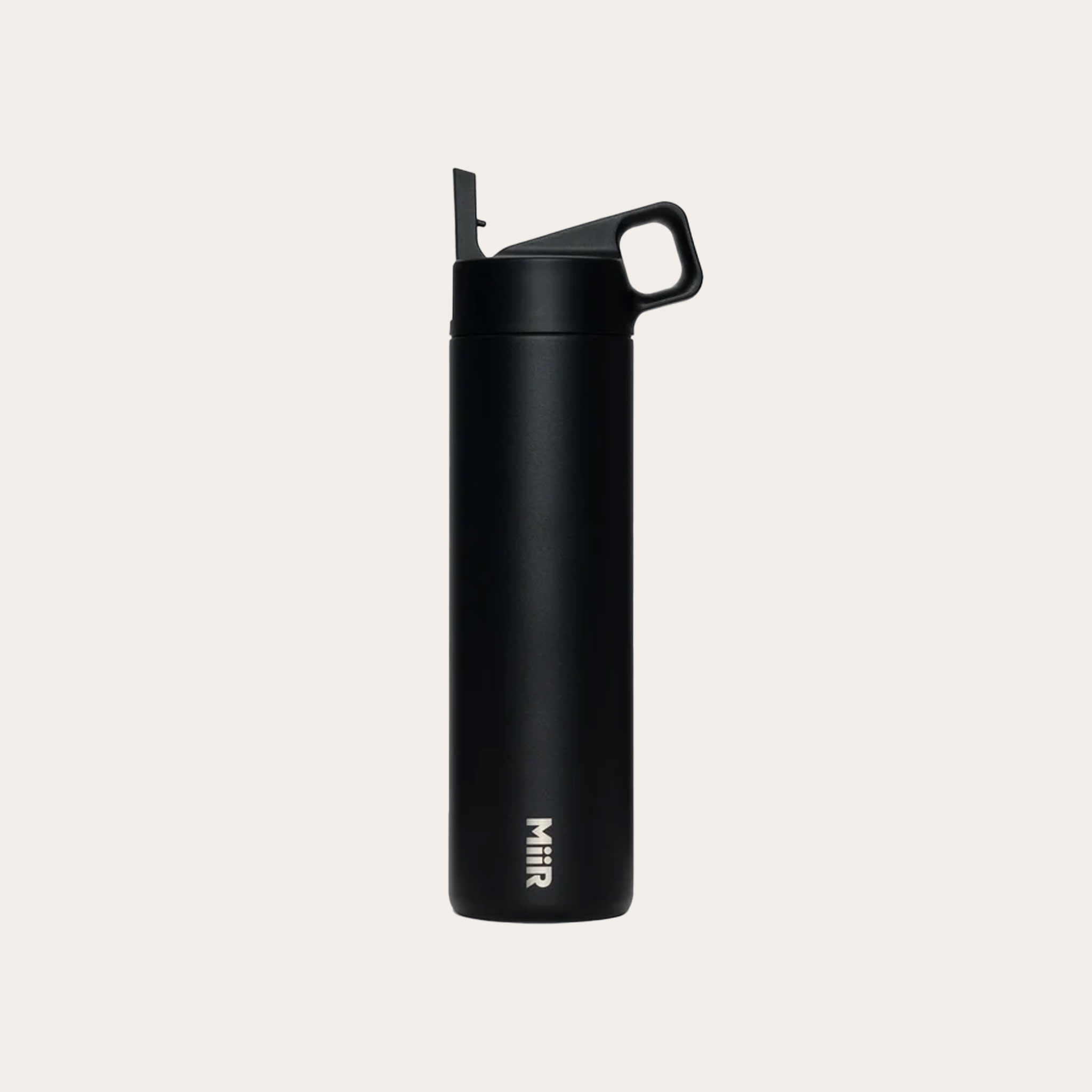 Black water bottle with straw, handle and MiiR logo placed on a tan background.