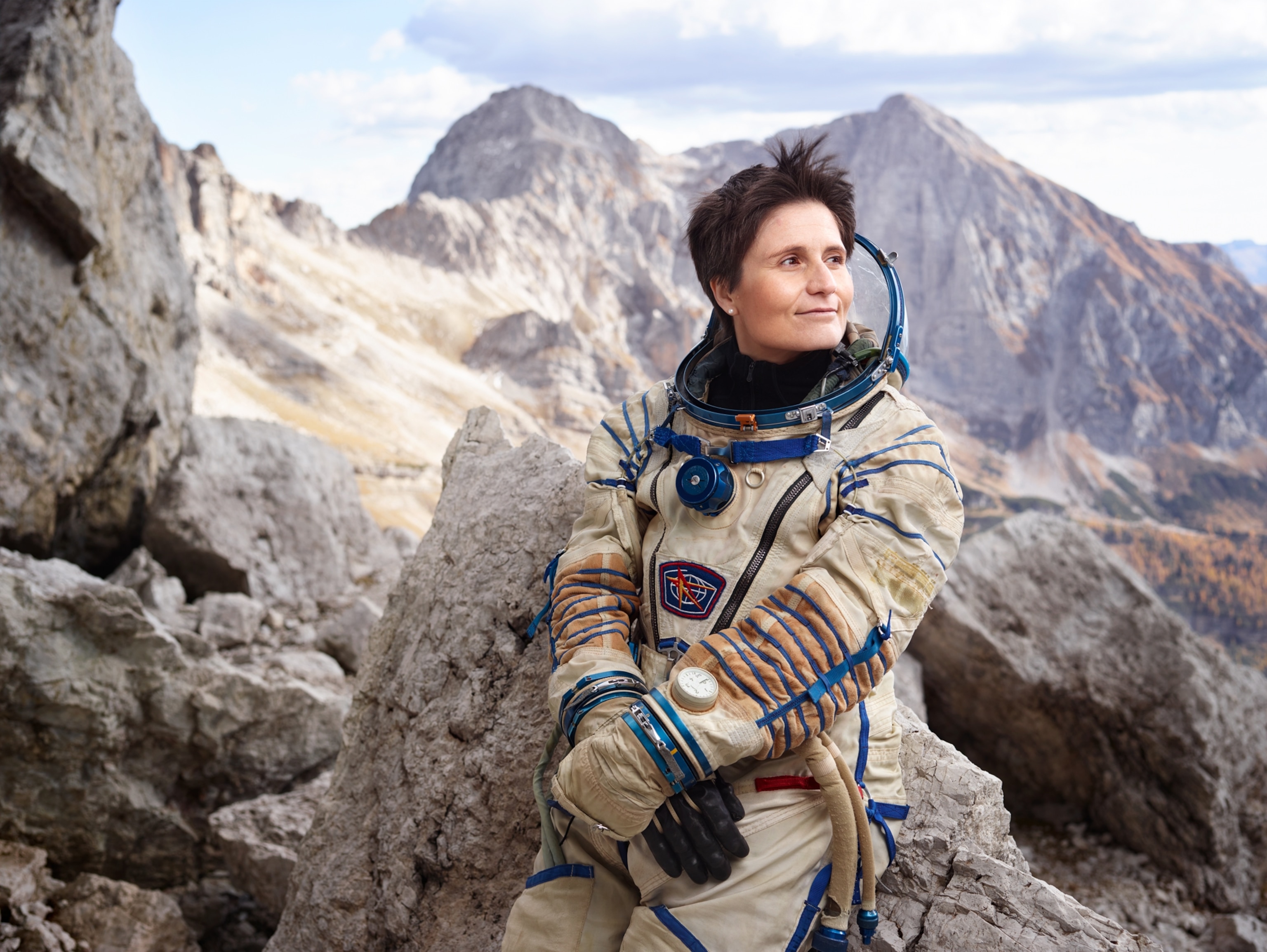 Samantha Cristoforetti sitting against a rock in the Italian alps looking outwards
