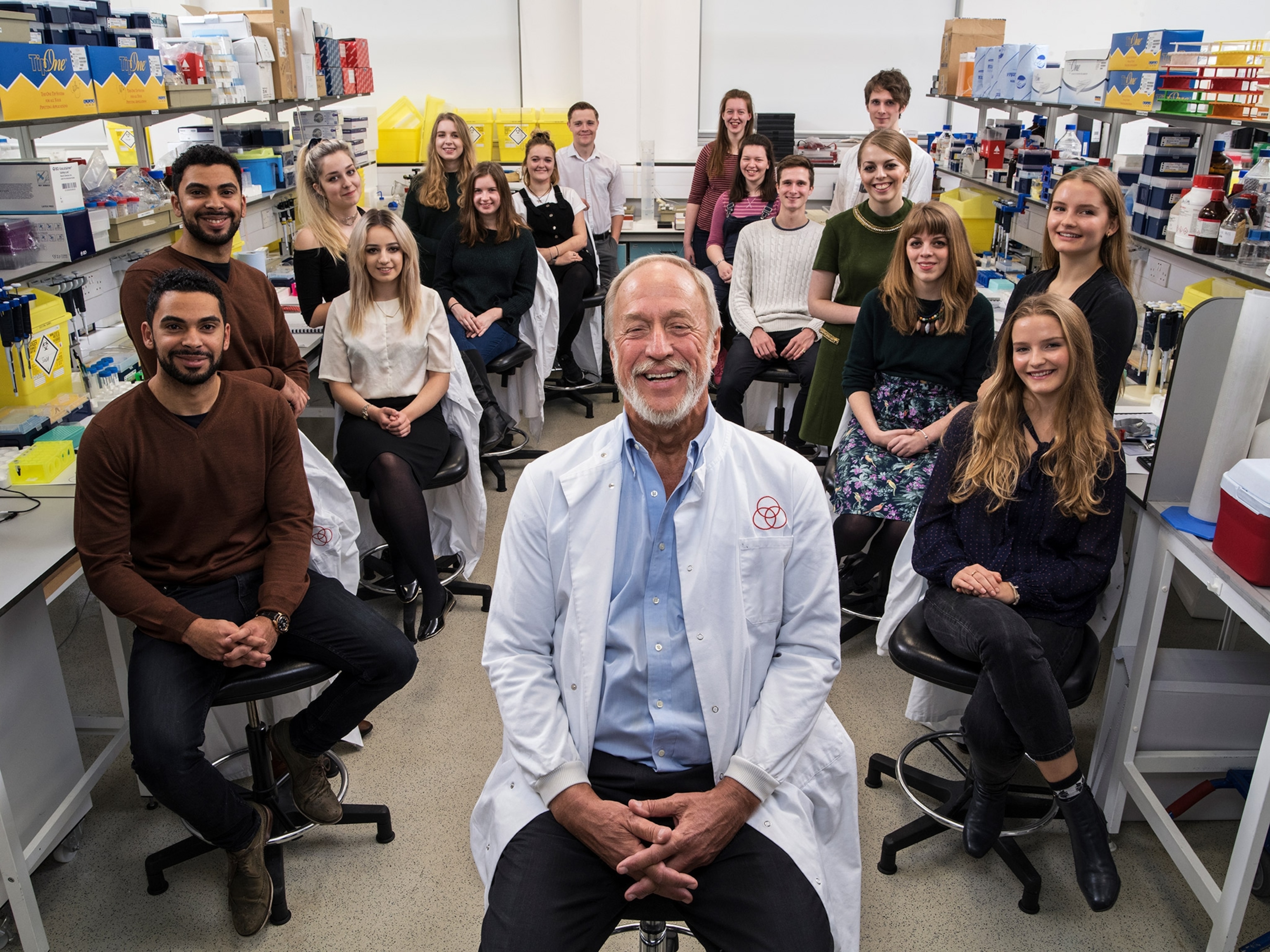 A group of twins sit around a researcher.