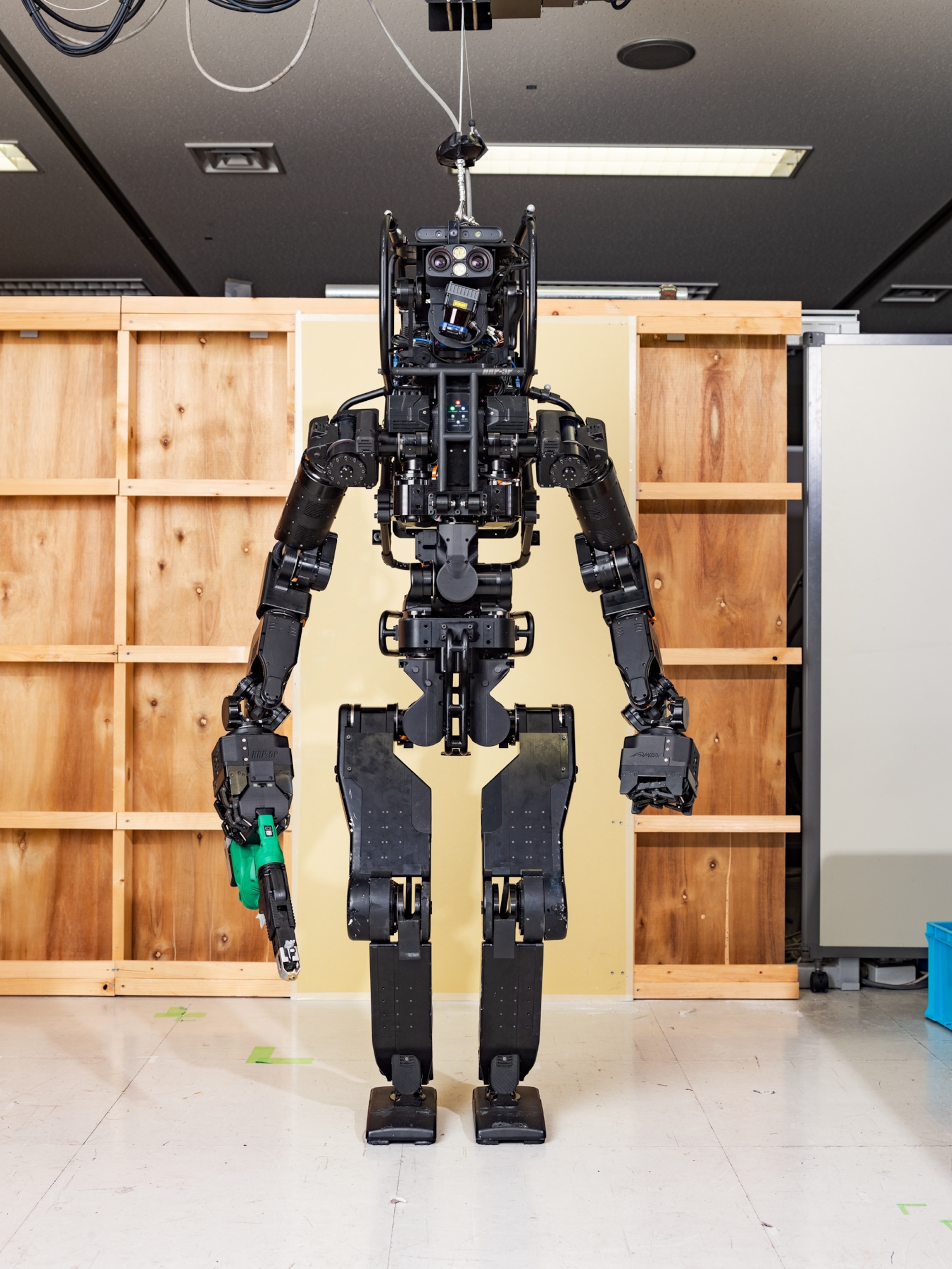 tall black metal robot with cover tool in his right hand.
