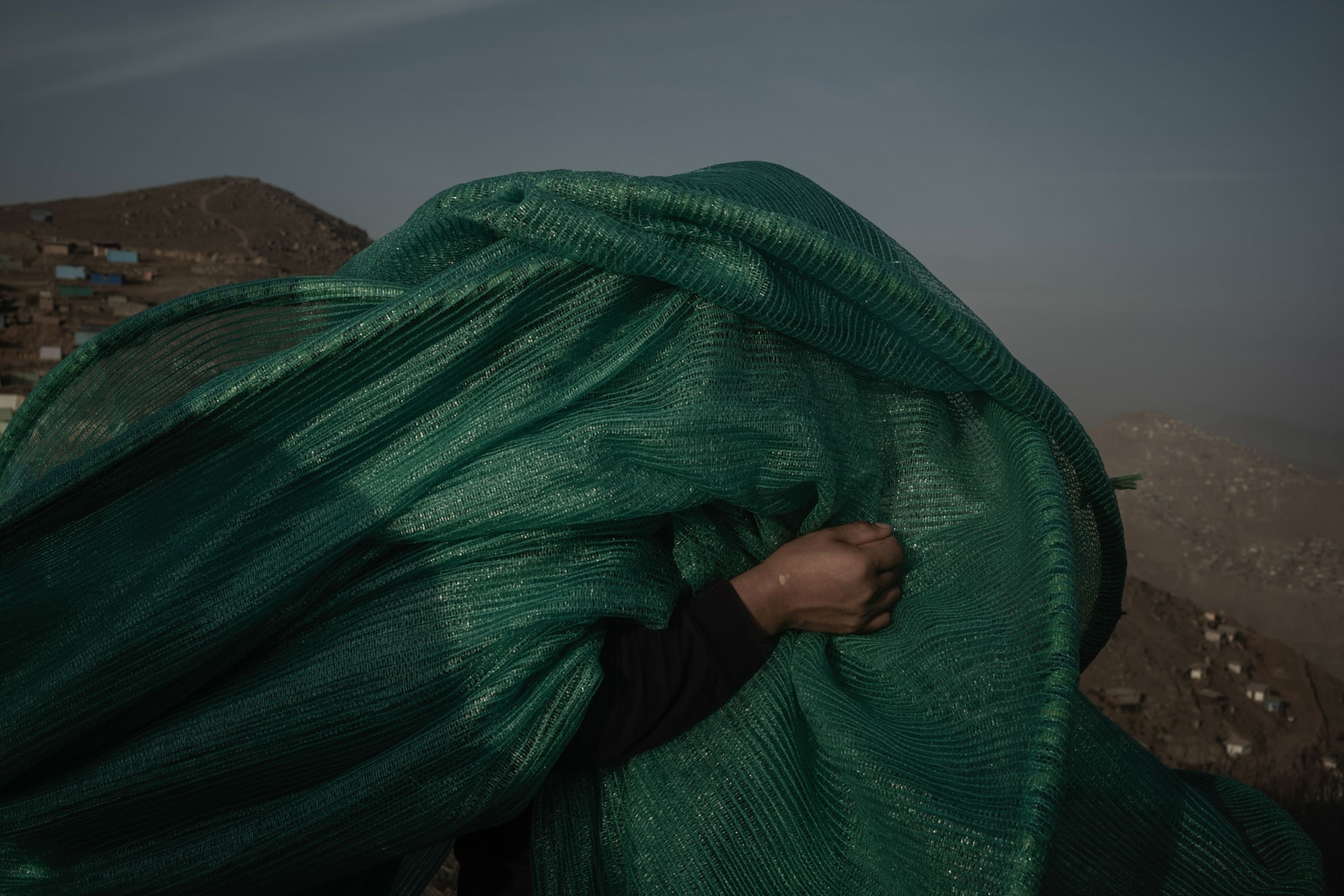 A woman carrying a net to be installed by her fellow neighbours members