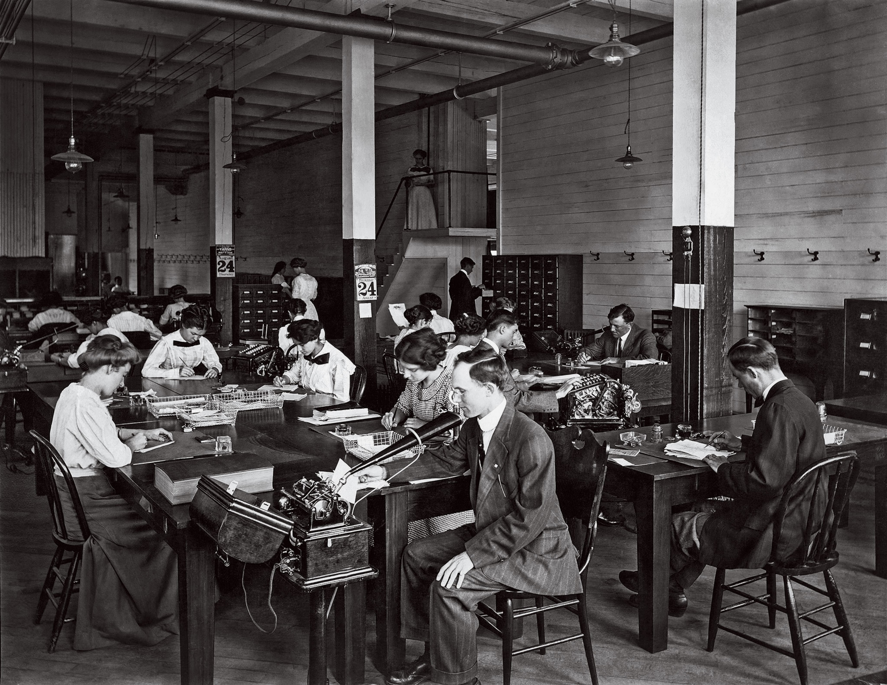A black-and-white image of workers with desks and vertical filing cabinets in a D.C. office
