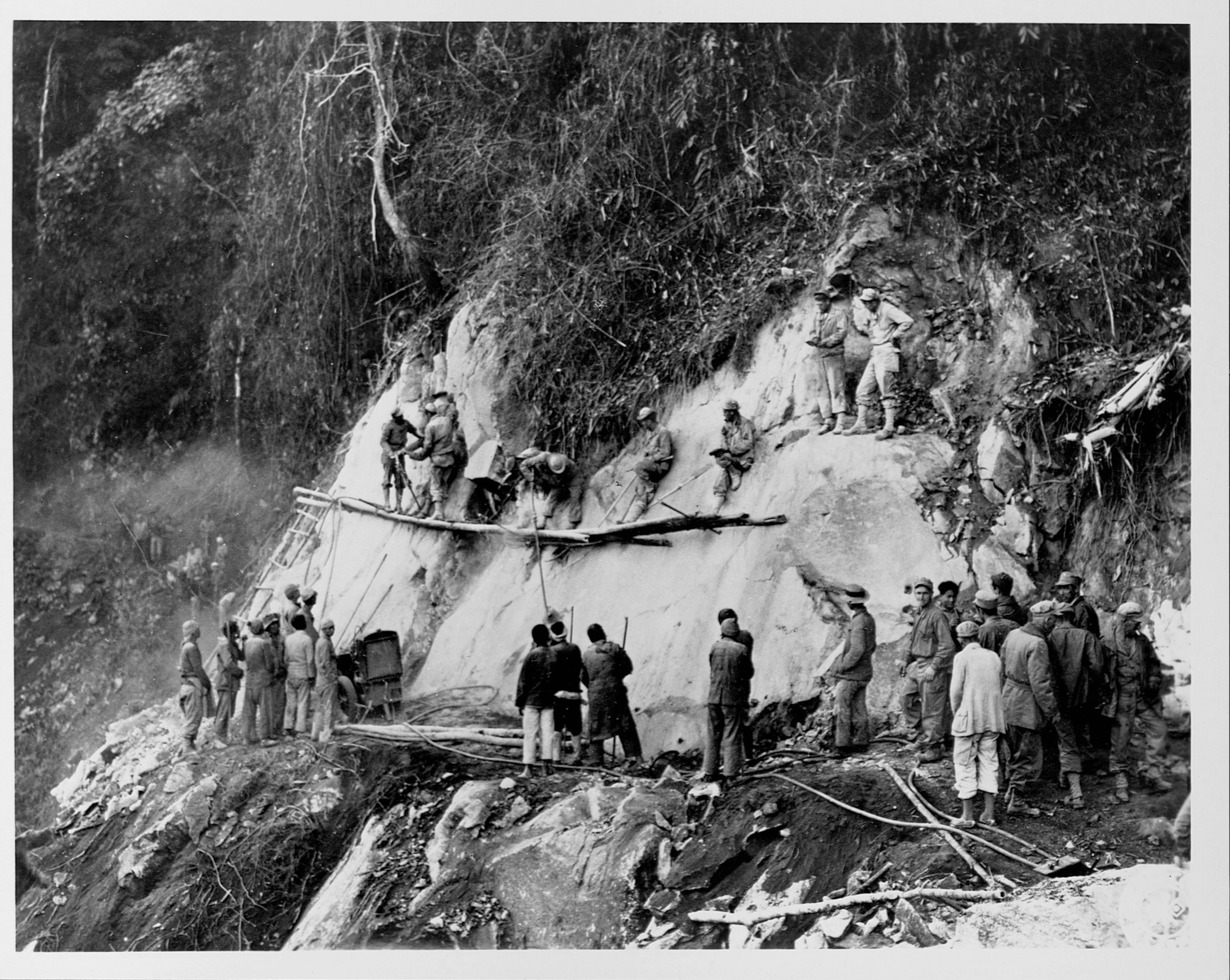 Photo of Chinese and American workers cutting through hillside in Burma