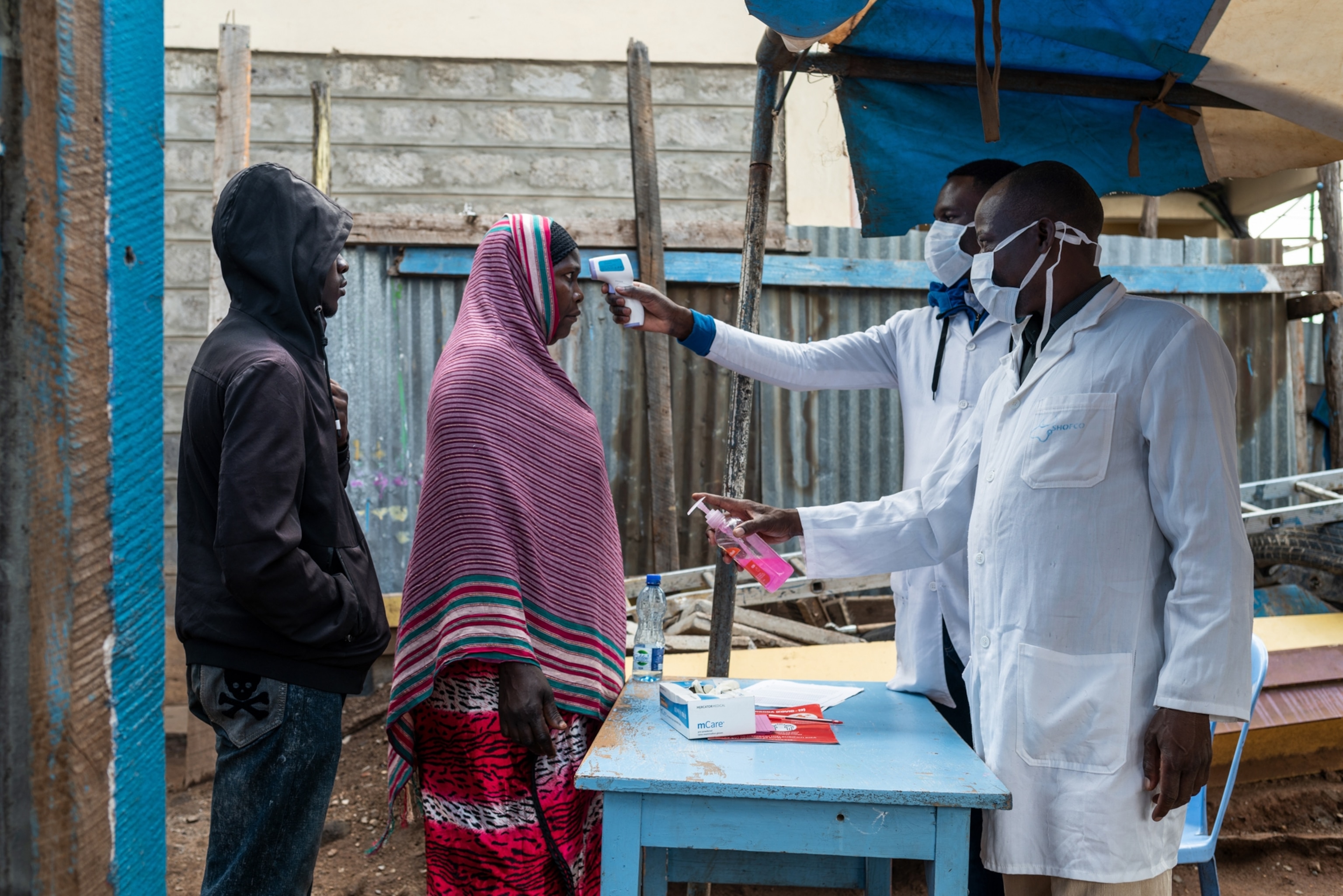 Residents have their temperature checked by community health worker in Nairobi, Kenya