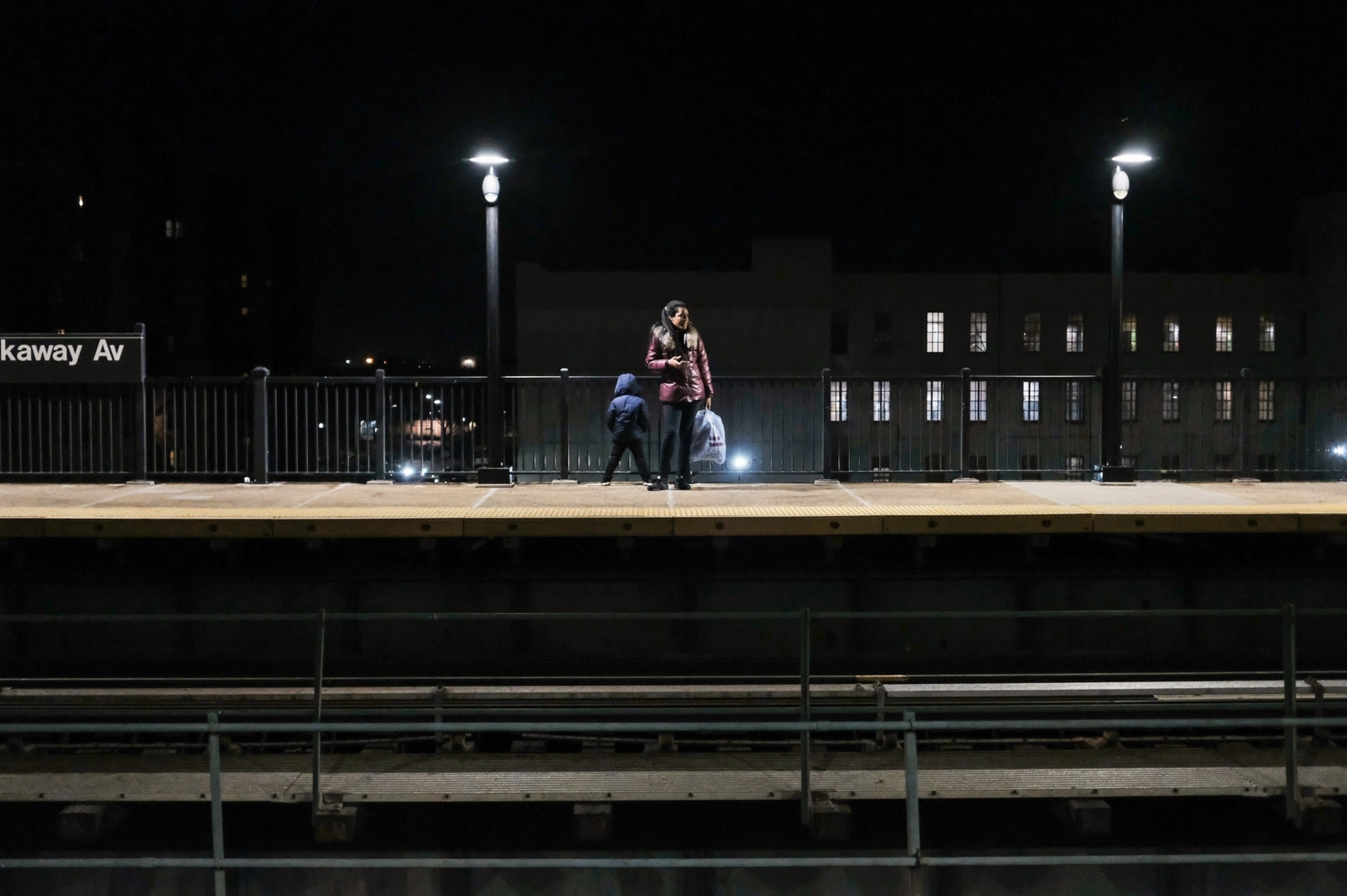 a woman standing on a subway platform in the dark