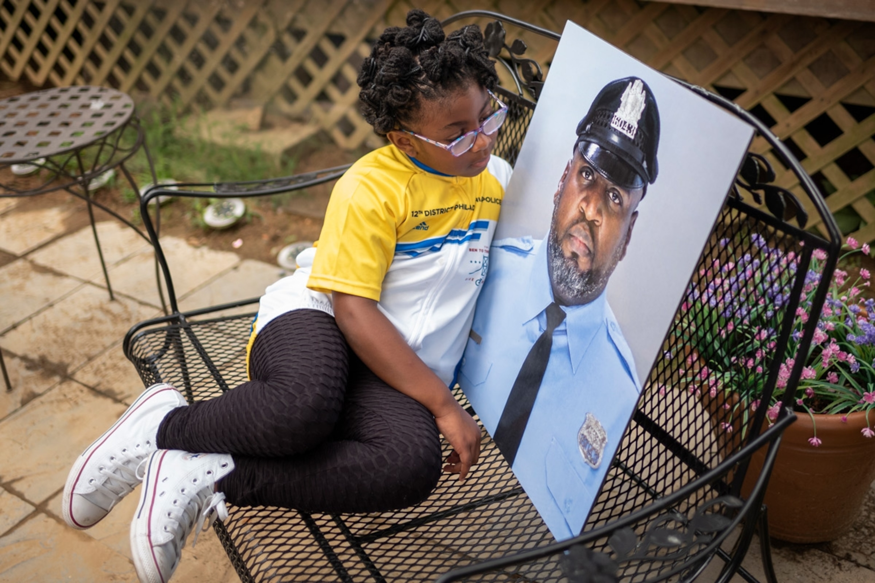 Amethyst, the five-year old daughter of Erin "Toke" Tokley, a Philadelphia cop who died from COVID-19 in March, poses with a portrait of her father on Aug. 29, 2021, in Secane, Pa. Tokley was scheduled to be vaccinated on March 11 – which turned out to be his funeral.