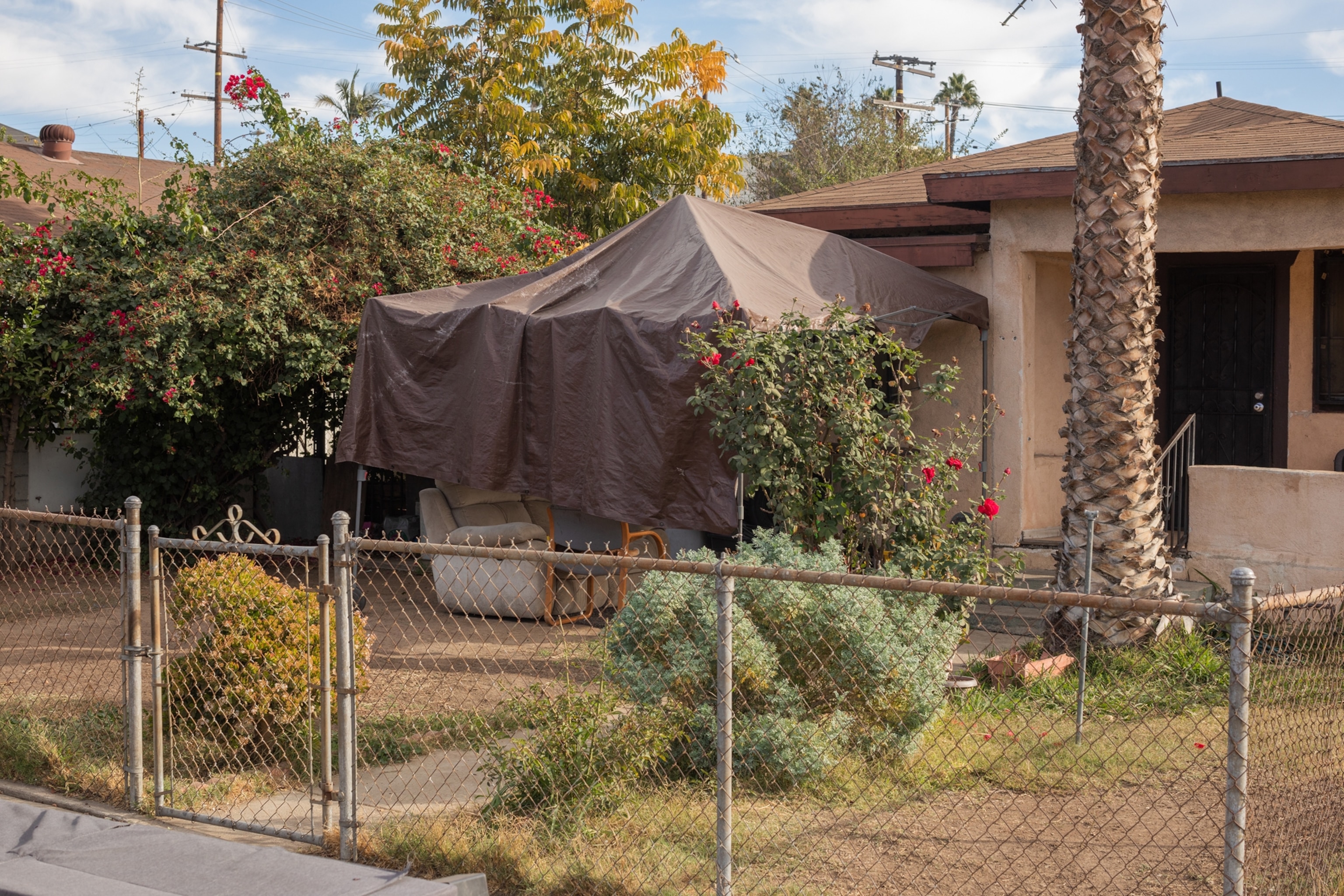 Picture of what looks like a family room completely covered by brown tarp on canopy frame