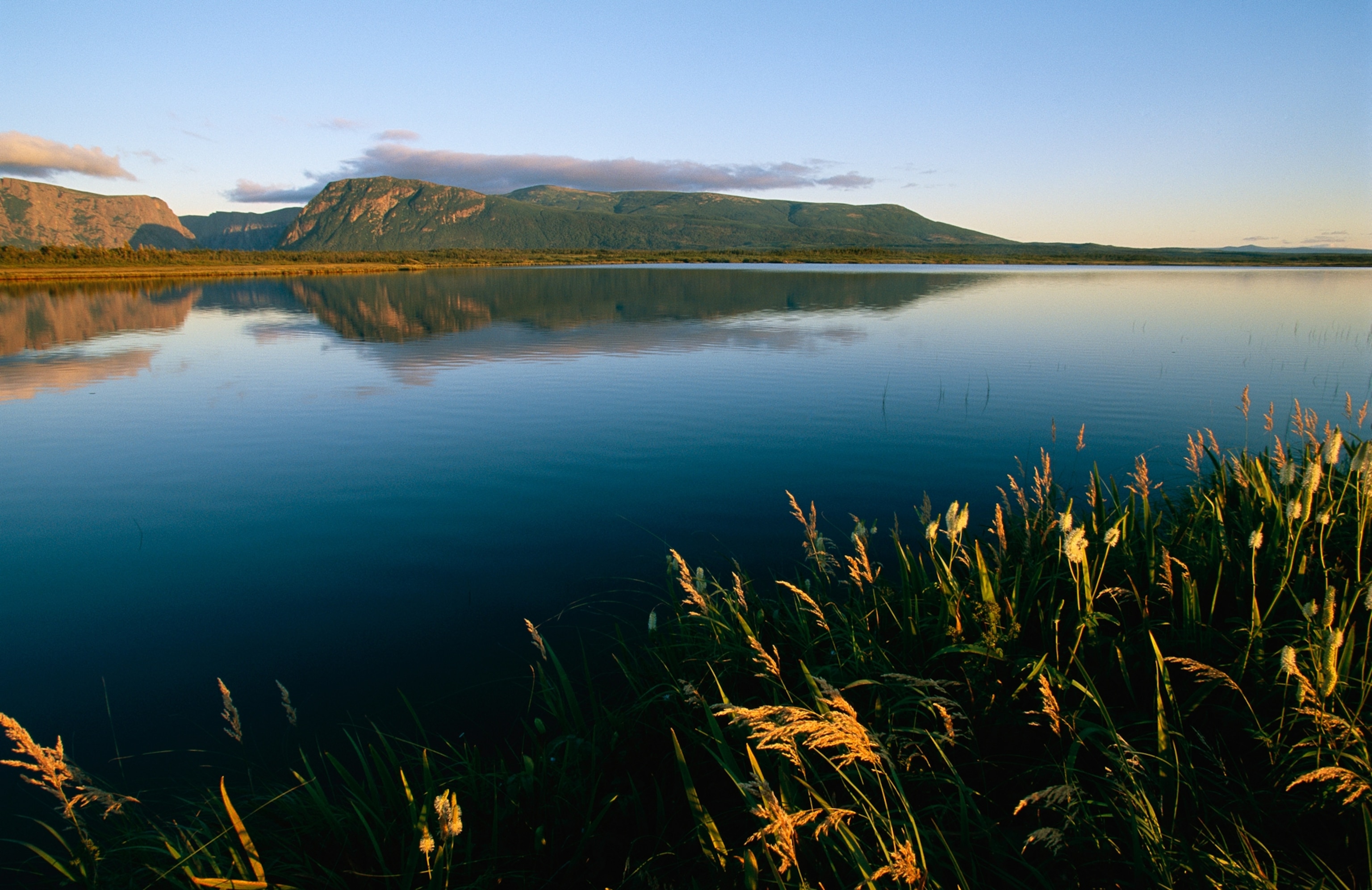 Scenic view of a large pond and hills at twilight