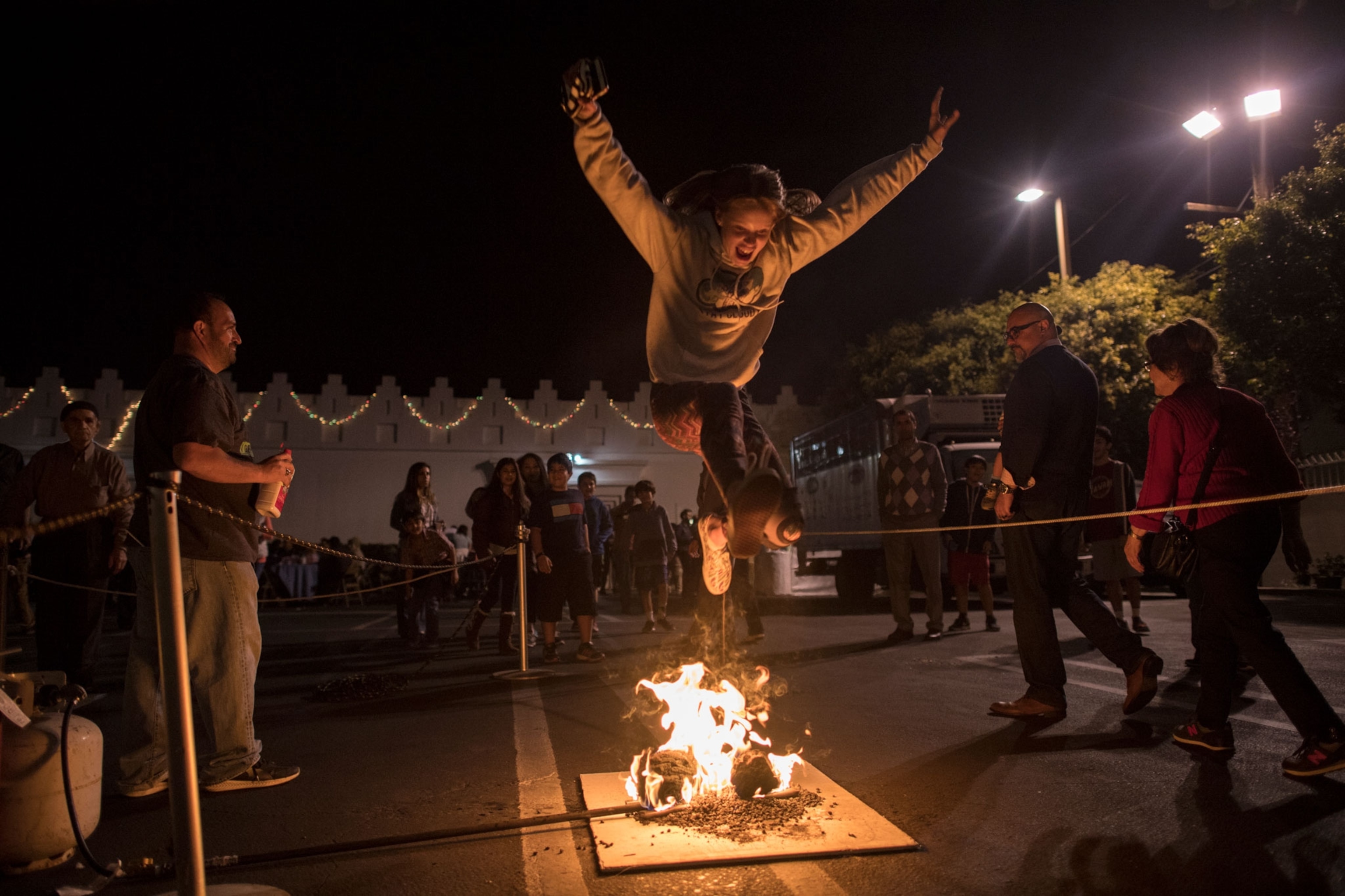 a person leaping over a small fire