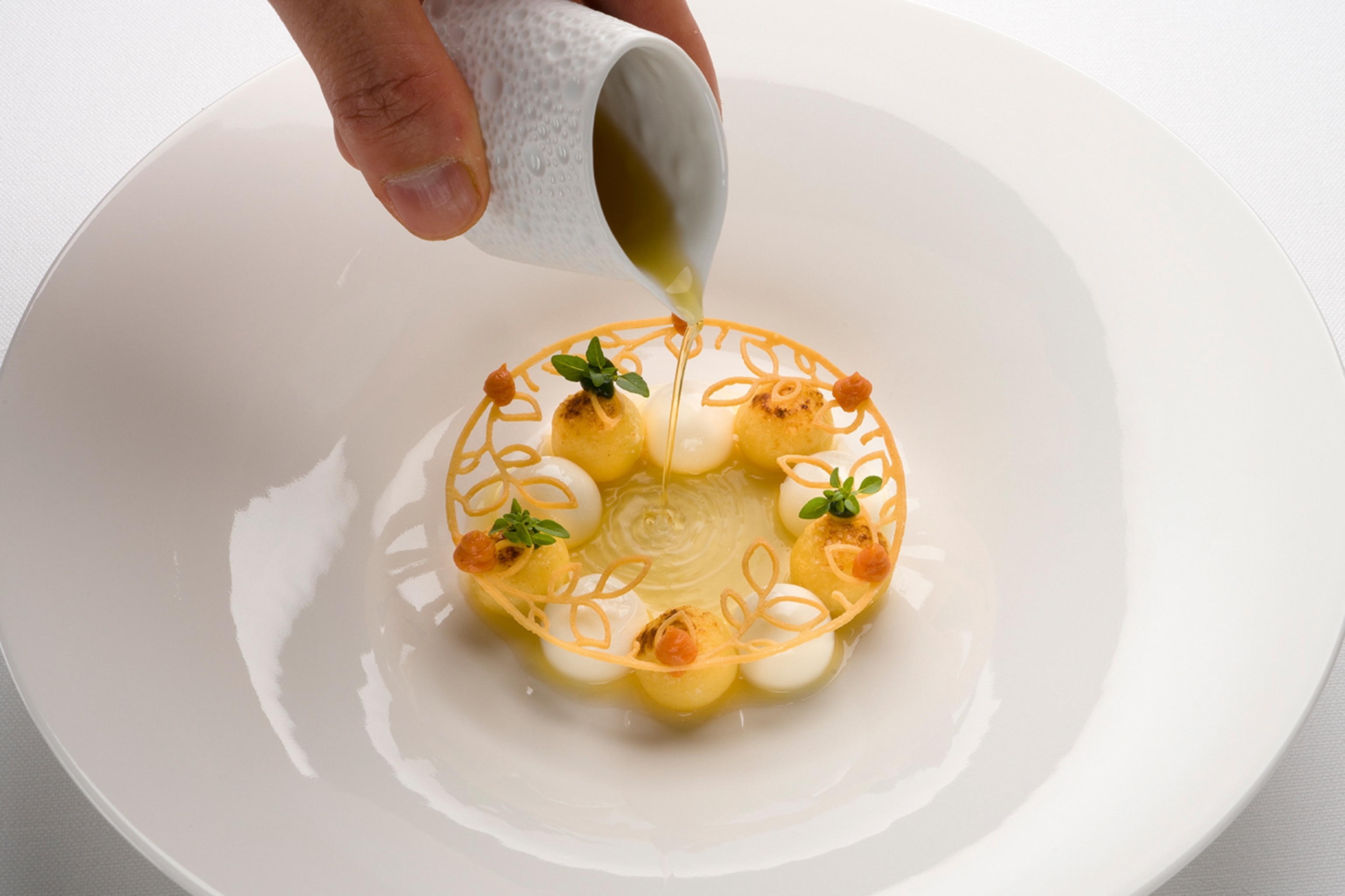 Pouring liquid over a dish of gnocchi