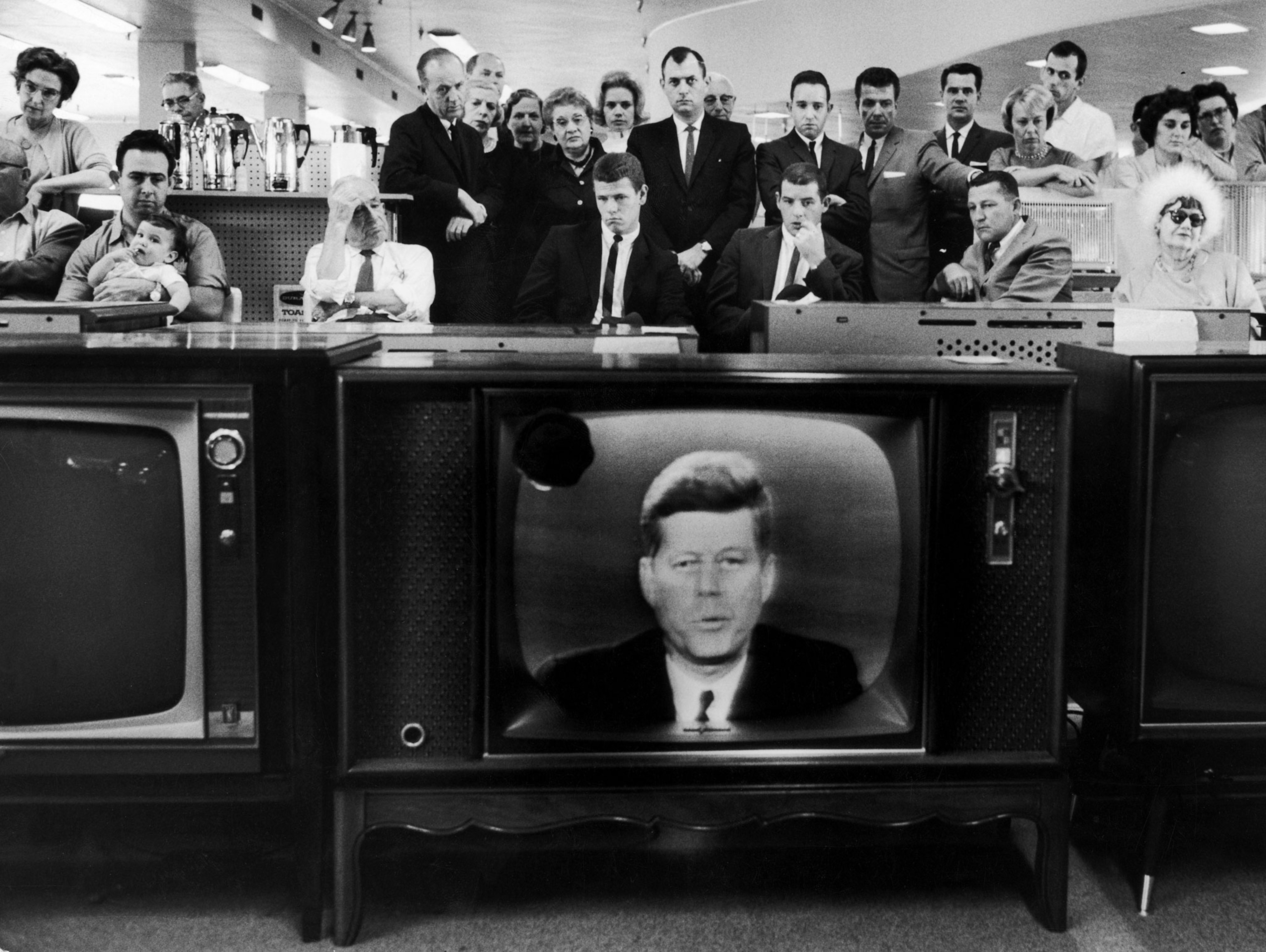 people watching JFK on a television