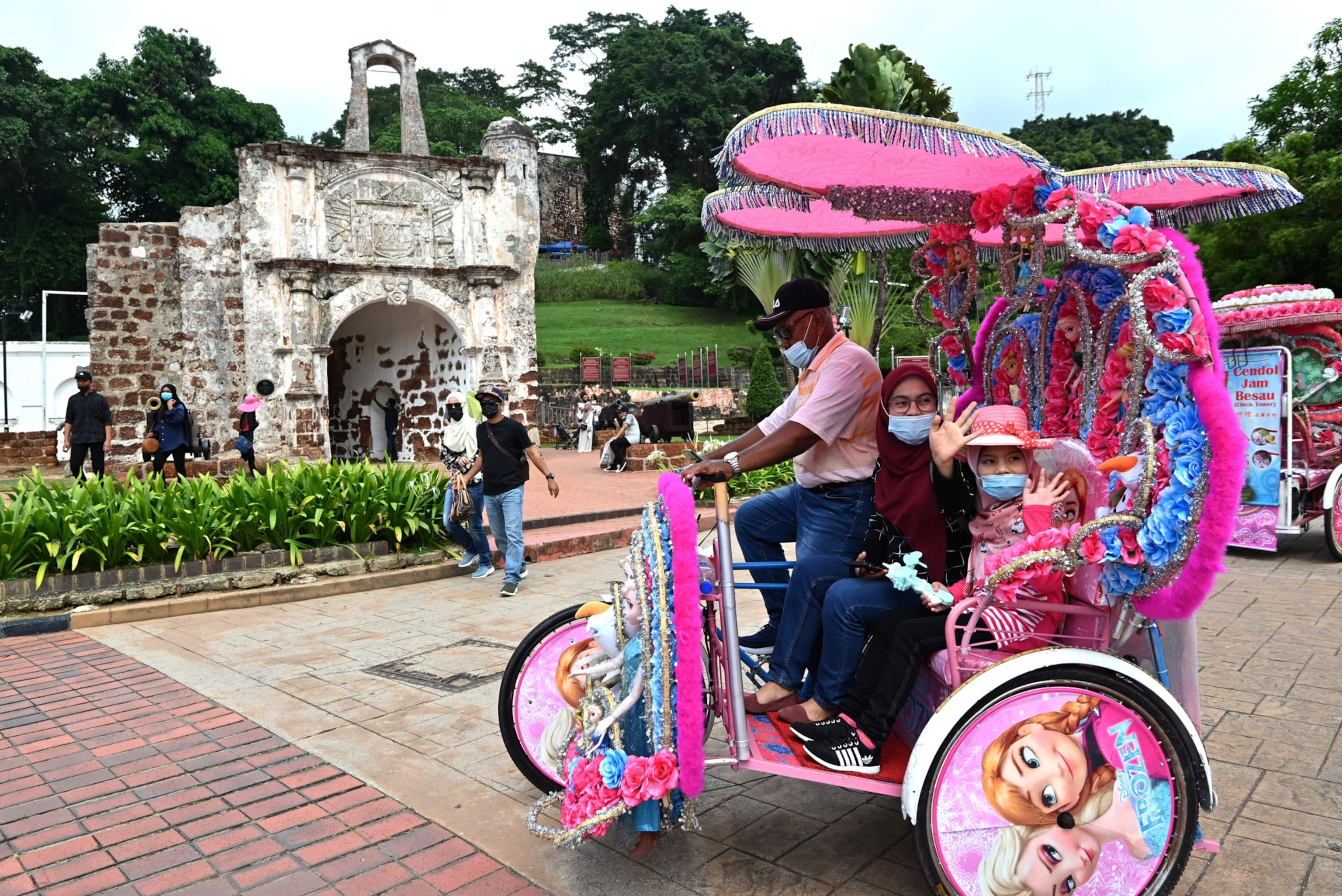 A pink kart carries a woman and young girl.