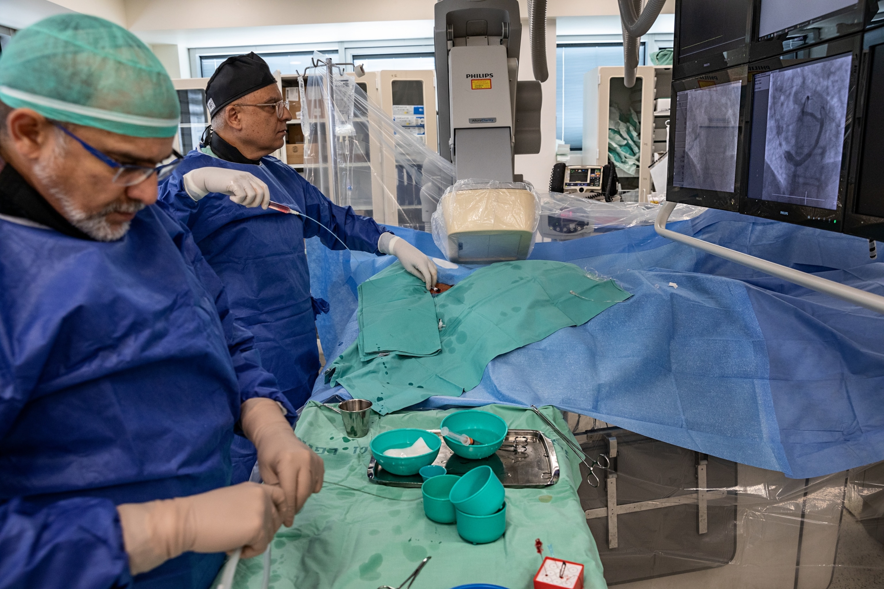 men in blue garbs doing medical procedure.