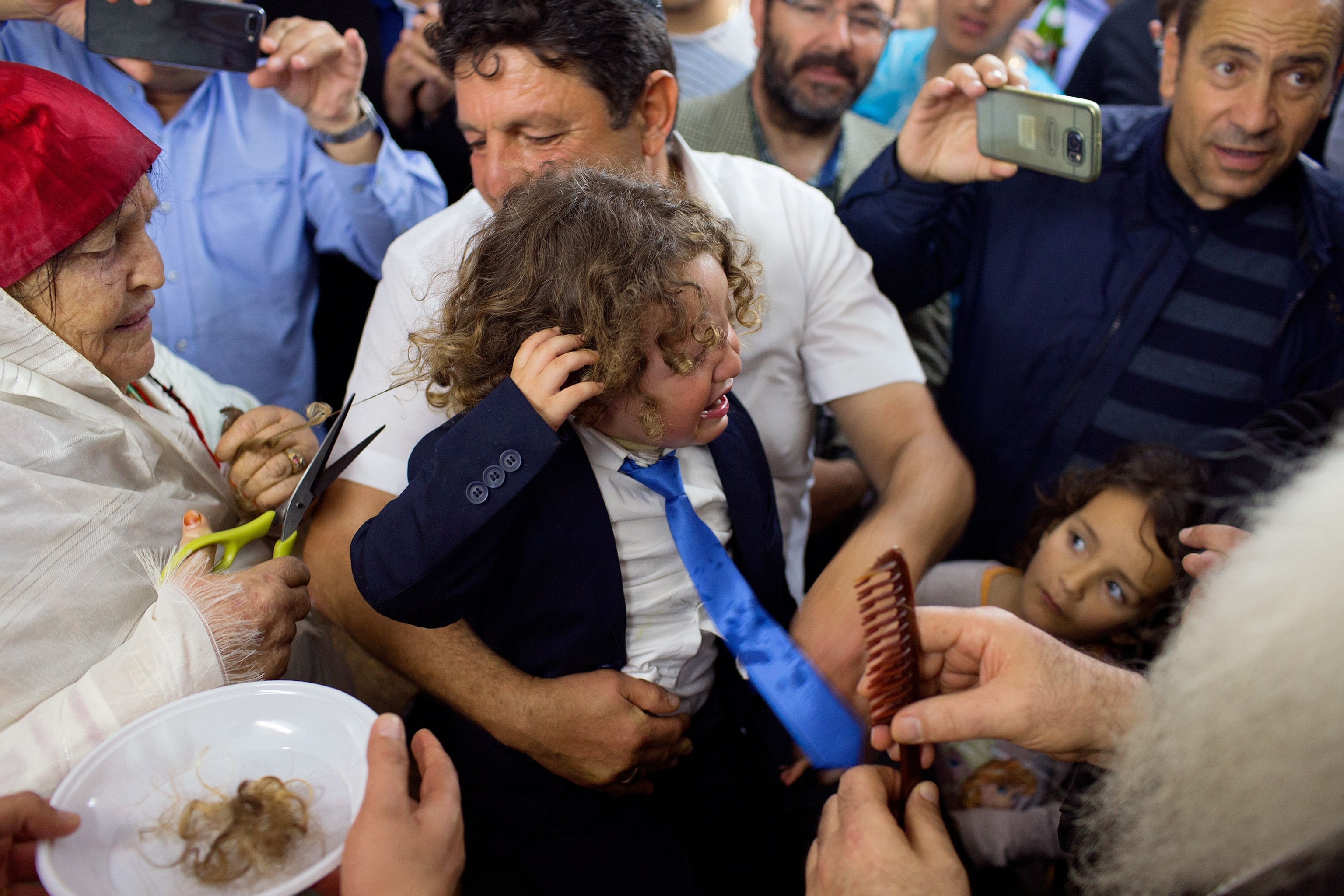 a boy crying during a haircutting ceremony during Lag BaOmer in Djerba, Tunisia