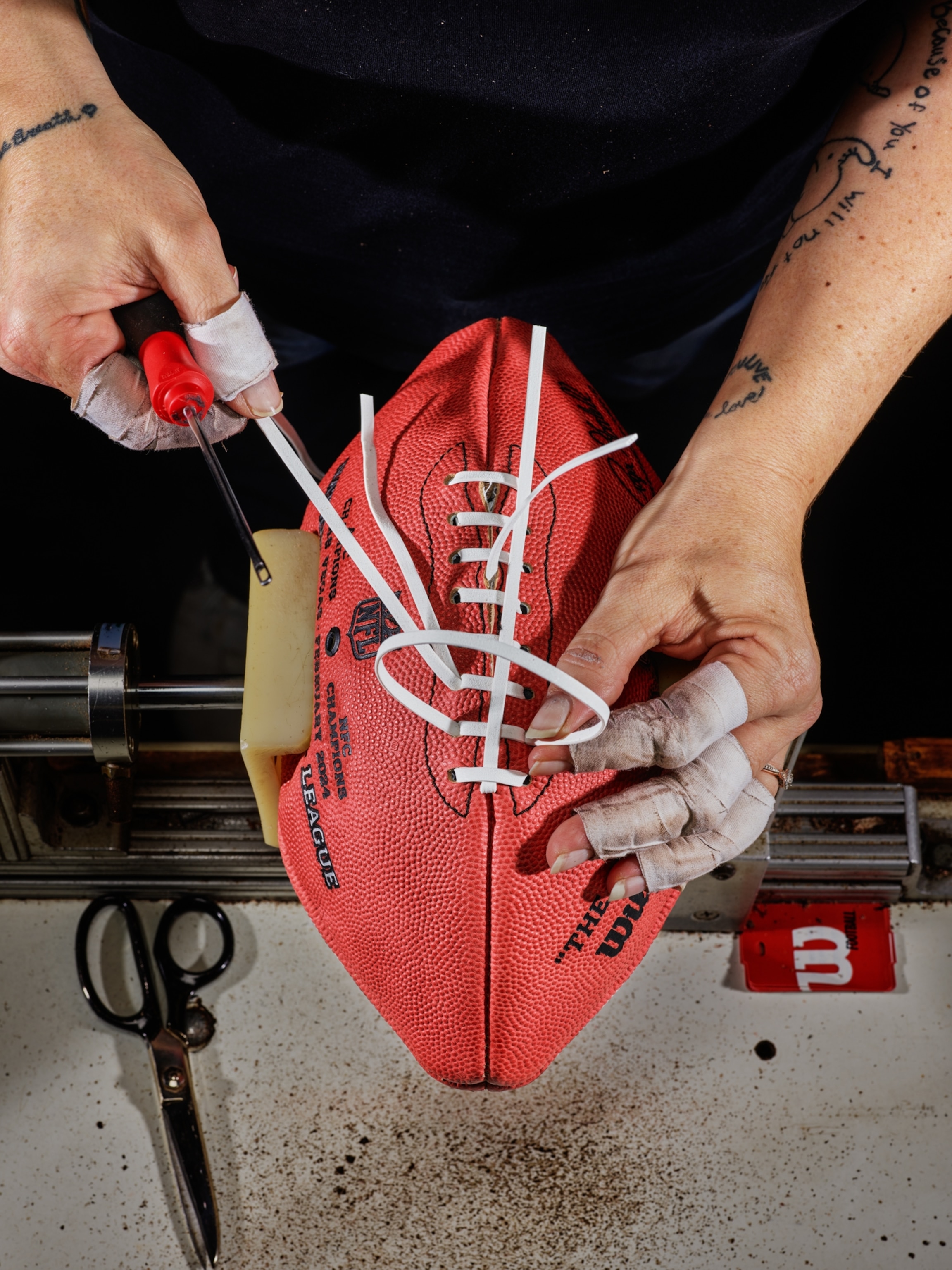 A lacer connecting a football.