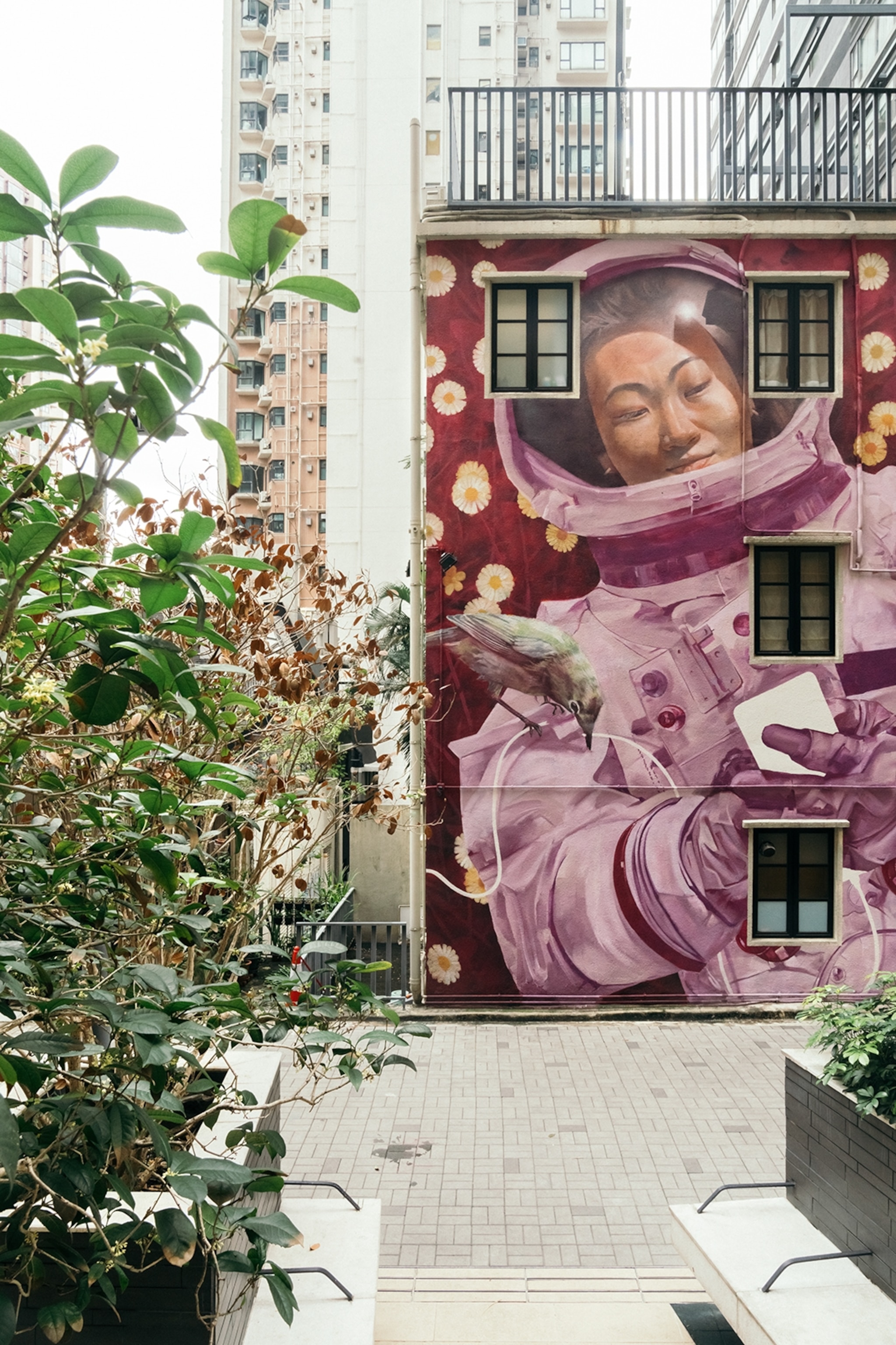 A colourful mural of a female astronaut on the side wall of a house.