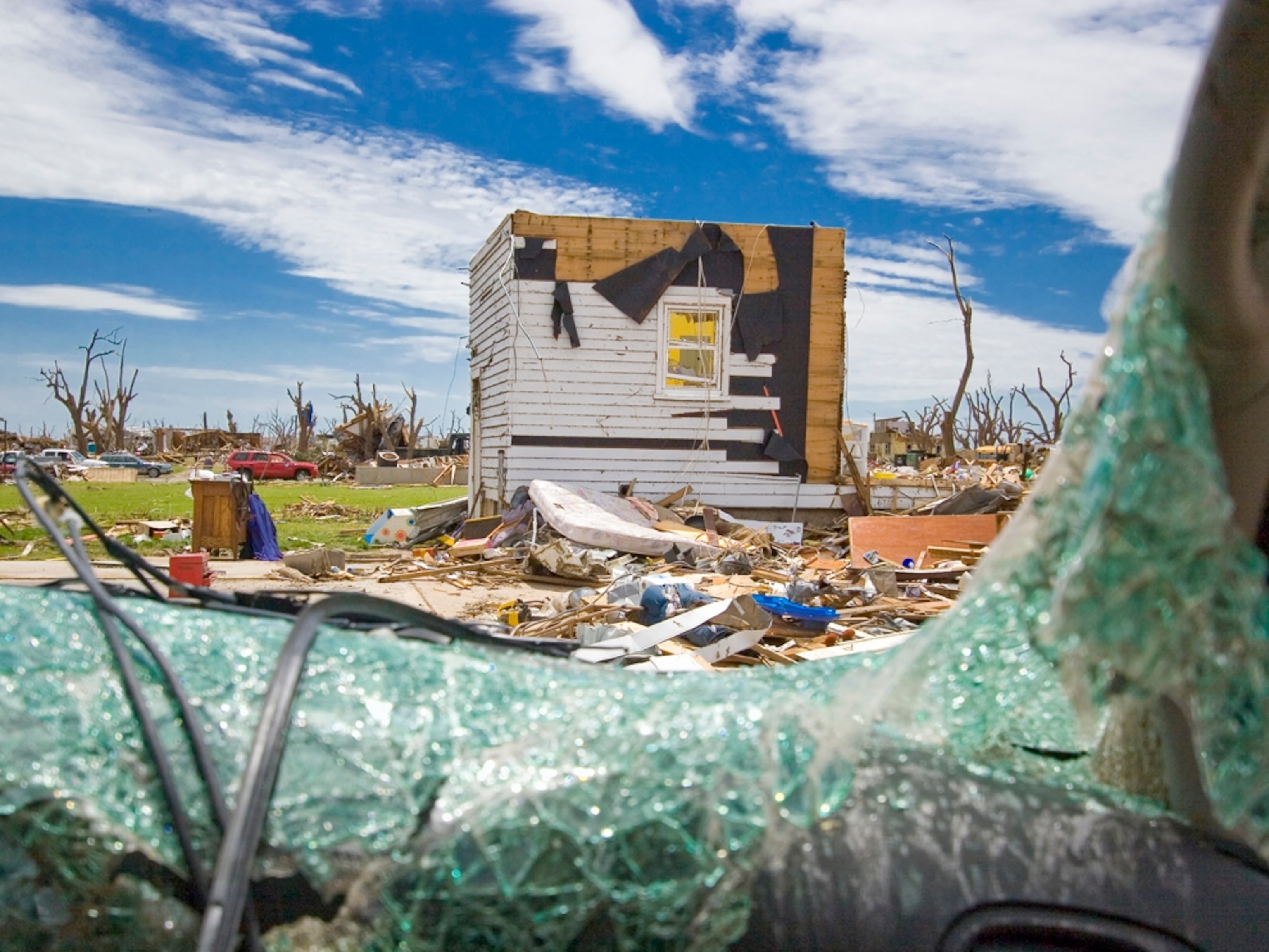A destroyed house through a broken safety glass window