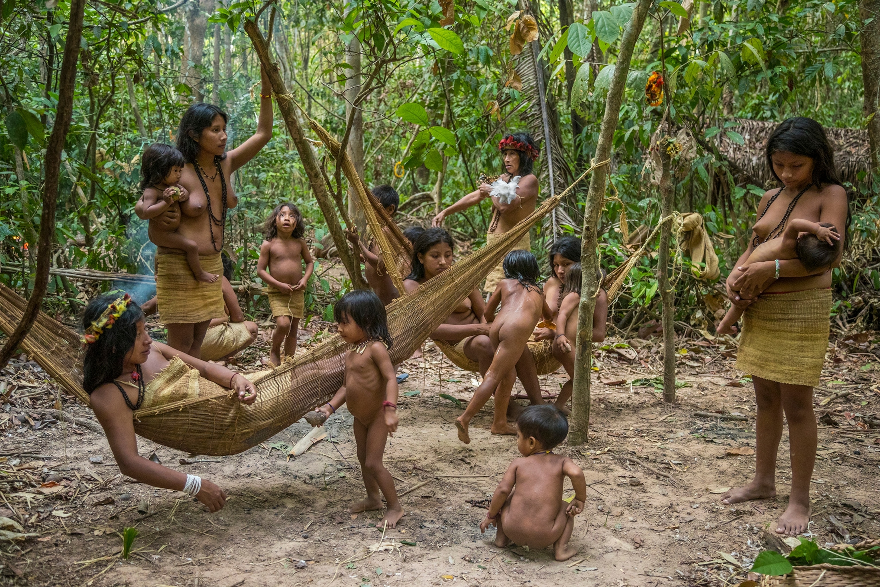 women and children relaxing on hammocks outside