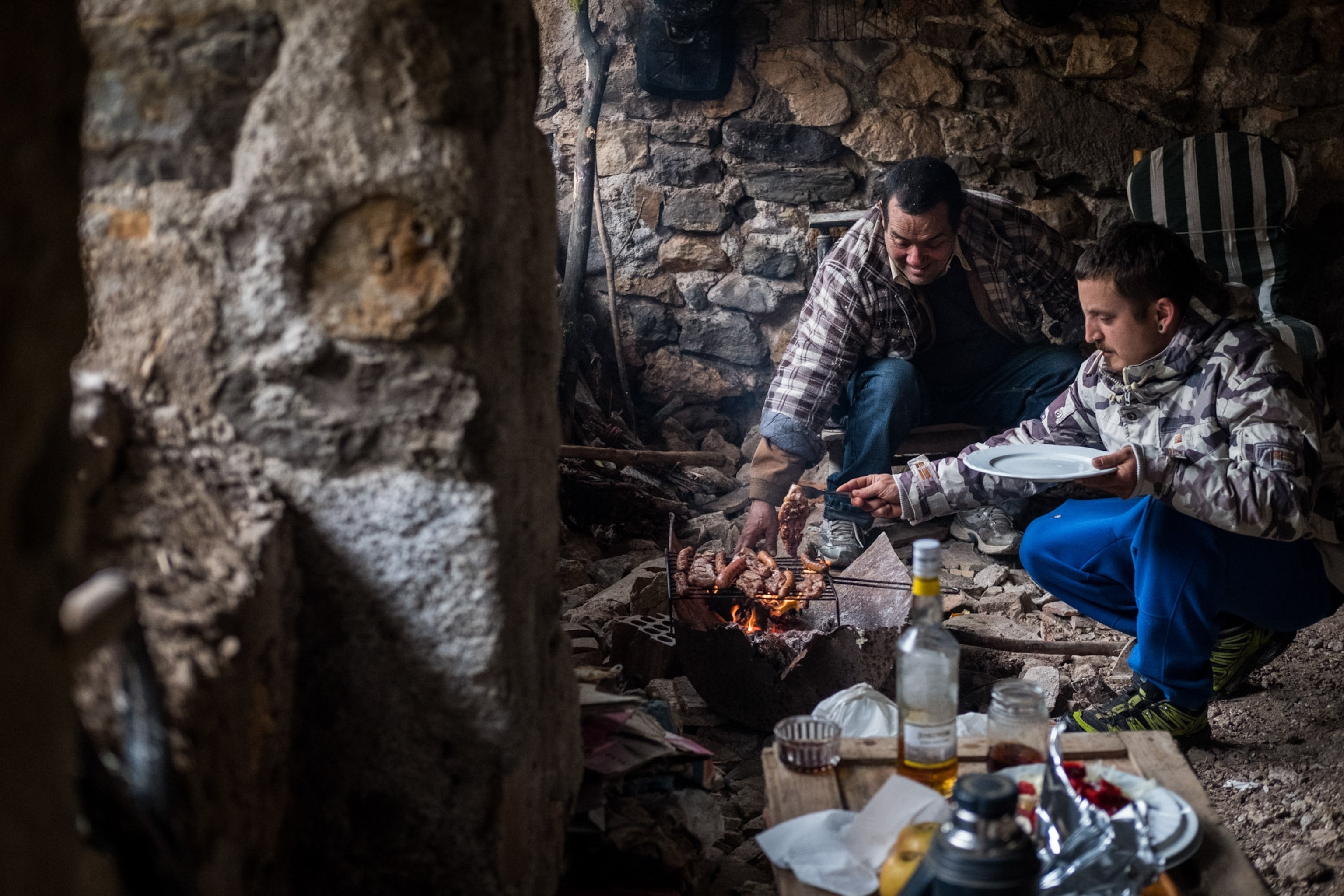 Two people sit and barbecue together.